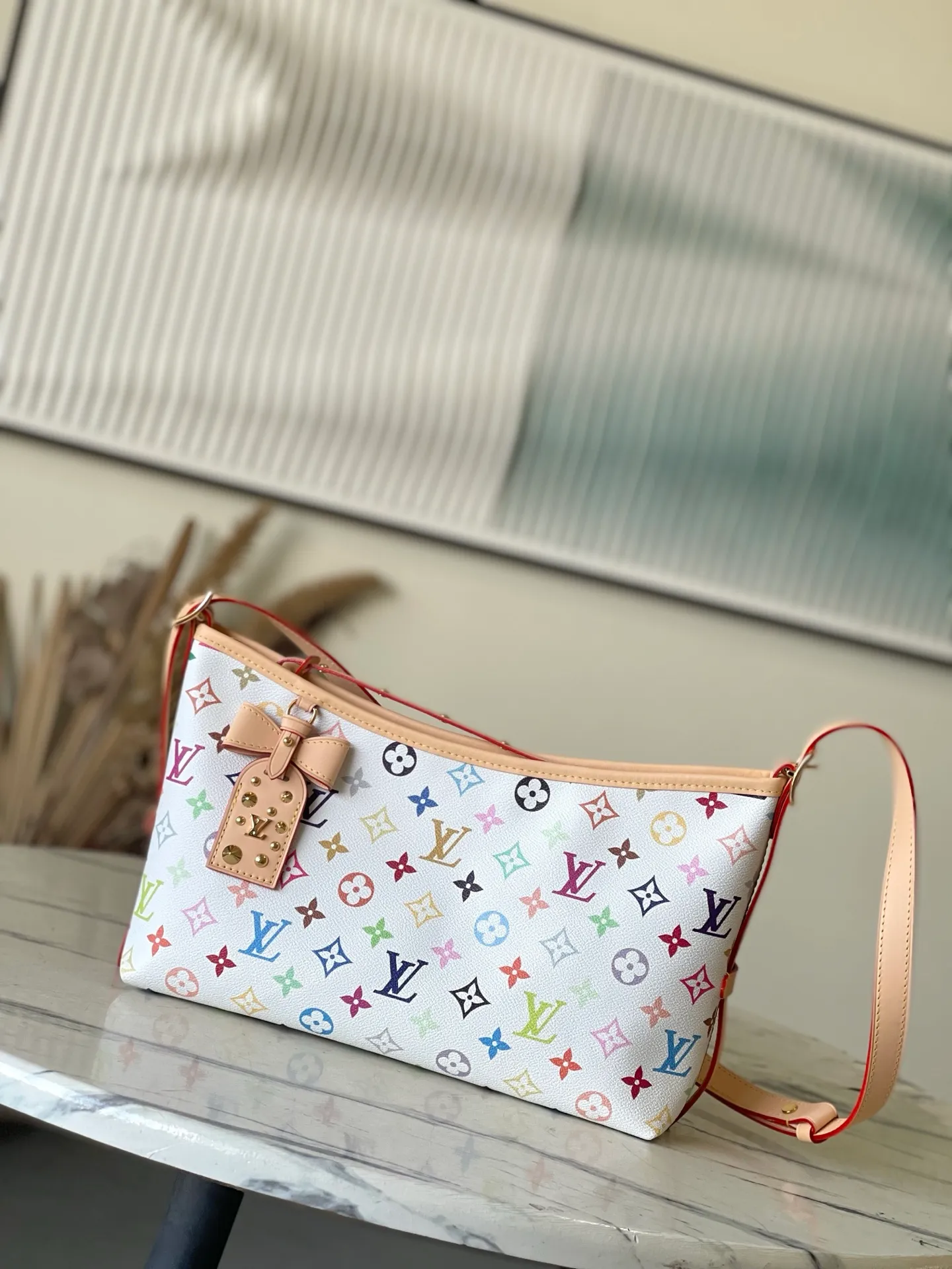 💰1100 Top Original Order M27578 To celebrate the 130th anniversary of the Louis Vuitton Monogram pattern, this Carryall East West canvas handbag illuminates this classic element with colorful colors. A leather tag inside commemorates the occasion, while an LV stud address plate and removable bow decoration add to the pleasant atmosphere. Dimensions: 36 × 19 × 0.5 cm