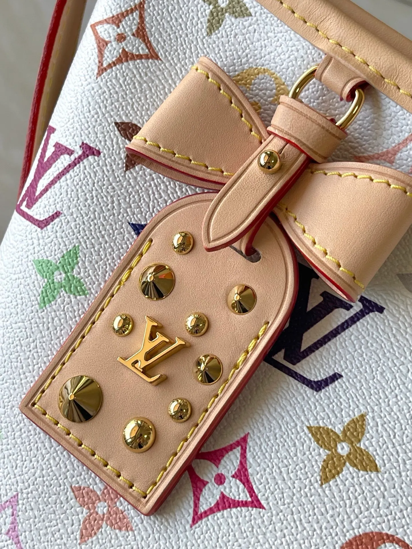 💰1100 Top Original Order M27578 To celebrate the 130th anniversary of the Louis Vuitton Monogram pattern, this Carryall East West canvas handbag illuminates this classic element with colorful colors. A leather tag inside commemorates the occasion, while an LV stud address plate and removable bow decoration add to the pleasant atmosphere. Dimensions: 36 × 19 × 0.5 cm