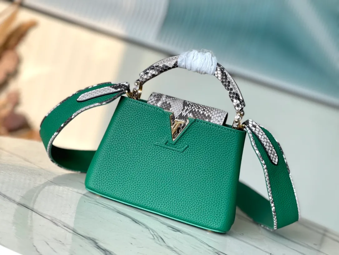 💰1860 (extra-grade original leather) N99387/M95509 green snake shoulder. This Capucines mini handbag is exquisitely constructed with full-grain Taurillon leather. It is equipped with a top handle, two flaps and a logo outlined in luster python leather, making it a gorgeous choice for both day and night. The detachable wide shoulder strap allows for an avant-garde look when worn on the shoulder or crossbody. Size: 21 *14 * 8cm