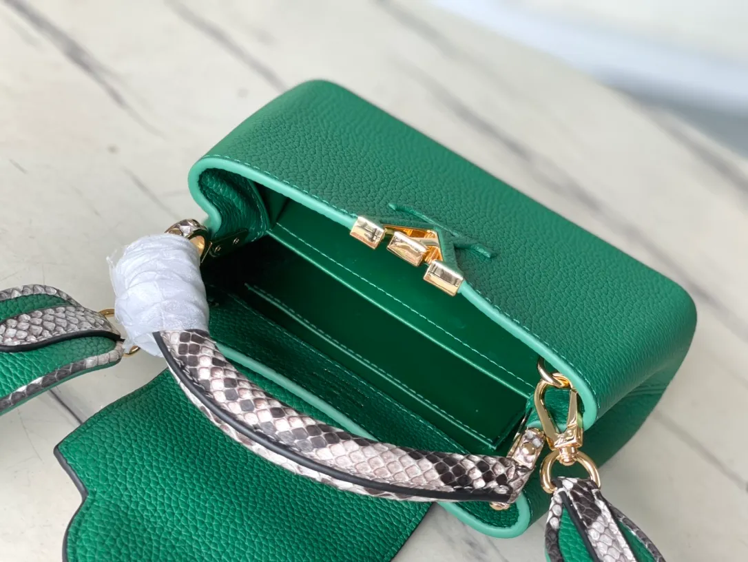 💰1860 (extra-grade original leather) N99387/M95509 green snake shoulder. This Capucines mini handbag is exquisitely constructed with full-grain Taurillon leather. It is equipped with a top handle, two flaps and a logo outlined in luster python leather, making it a gorgeous choice for both day and night. The detachable wide shoulder strap allows for an avant-garde look when worn on the shoulder or crossbody. Size: 21 *14 * 8cm