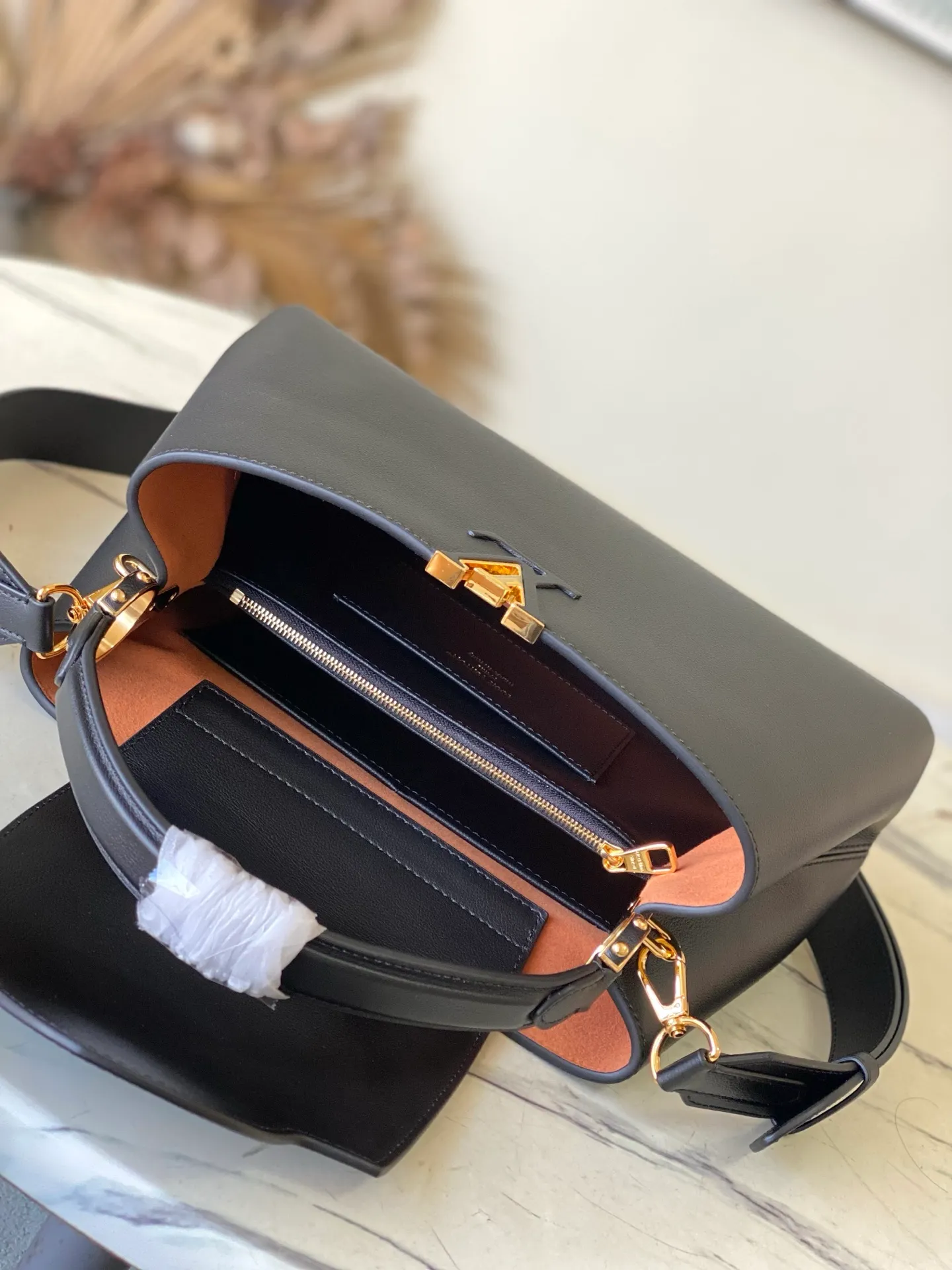 💰2360 "Special Original Leather" M14370 Black This Capucines Souple medium handbag is made of fine grained cow leather, with a sharp contrast of suede lining and dazzling metal parts, and uses the LV letters to express the brand heritage. The flip cover can be folded in or out, and the compartments and pockets can store your daily needs in an orderly manner, and you can switch between various carrying methods at will. 33.0 x 24.0 x 12.0 cm