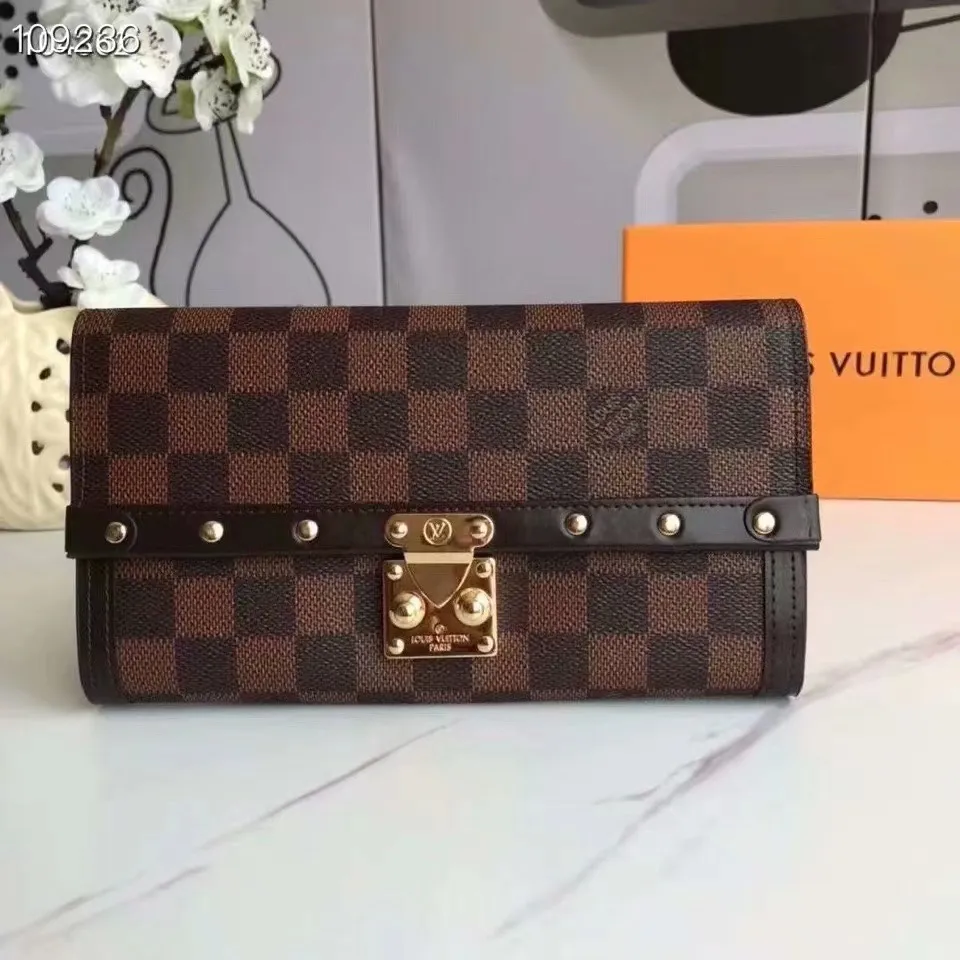 P160N60535 Material: PVC with cowhide leather Size: 21/10 Crafted from Damier Ebene canvas and decorated with the iconic S lock and rivets, this stylish Venice wallet pays homage to Louis Vuitton’s rich heritage as a luxury luggage manufacturer. Thanks to its spacious and functional interior, this model can also be used as an elegant clutch.