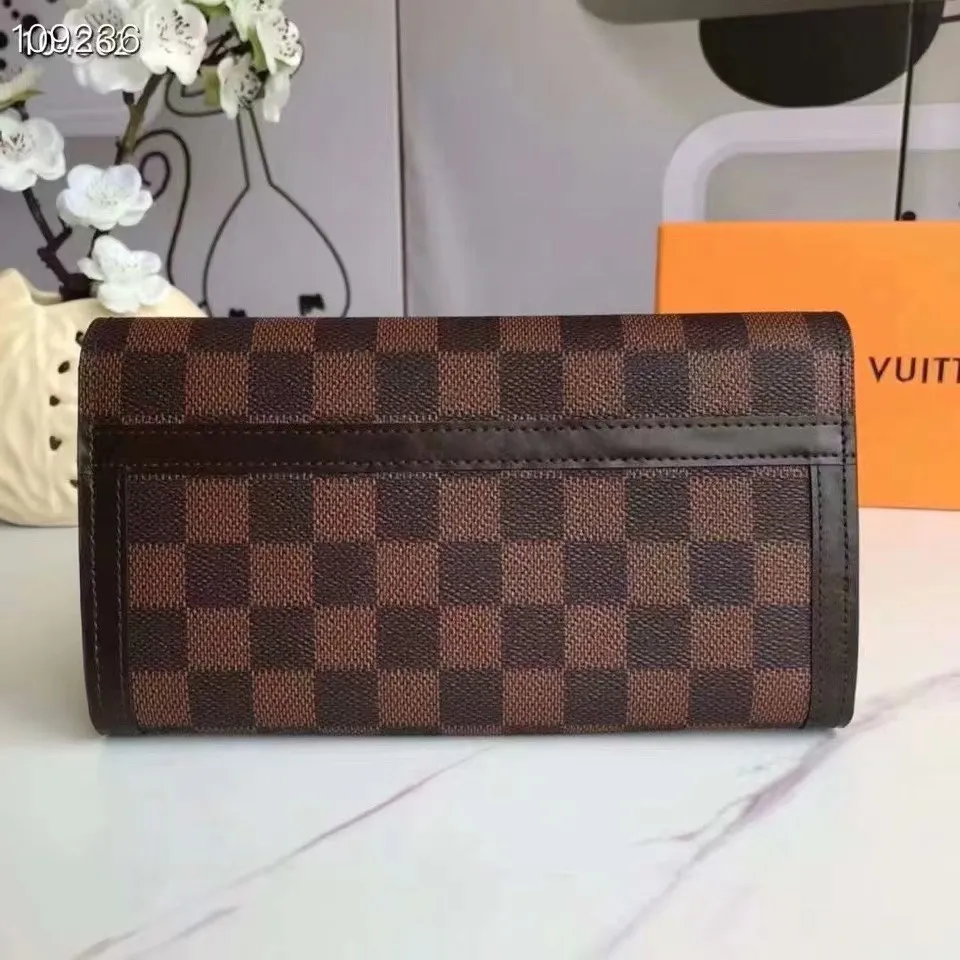P160N60535 Material: PVC with cowhide leather Size: 21/10 Crafted from Damier Ebene canvas and decorated with the iconic S lock and rivets, this stylish Venice wallet pays homage to Louis Vuitton’s rich heritage as a luxury luggage manufacturer. Thanks to its spacious and functional interior, this model can also be used as an elegant clutch.