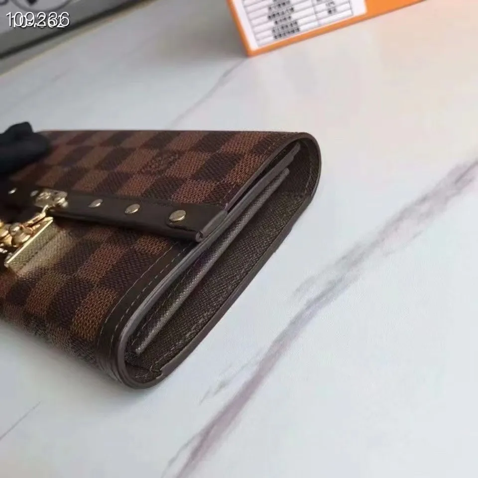 P160N60535 Material: PVC with cowhide leather Size: 21/10 Crafted from Damier Ebene canvas and decorated with the iconic S lock and rivets, this stylish Venice wallet pays homage to Louis Vuitton’s rich heritage as a luxury luggage manufacturer. Thanks to its spacious and functional interior, this model can also be used as an elegant clutch.