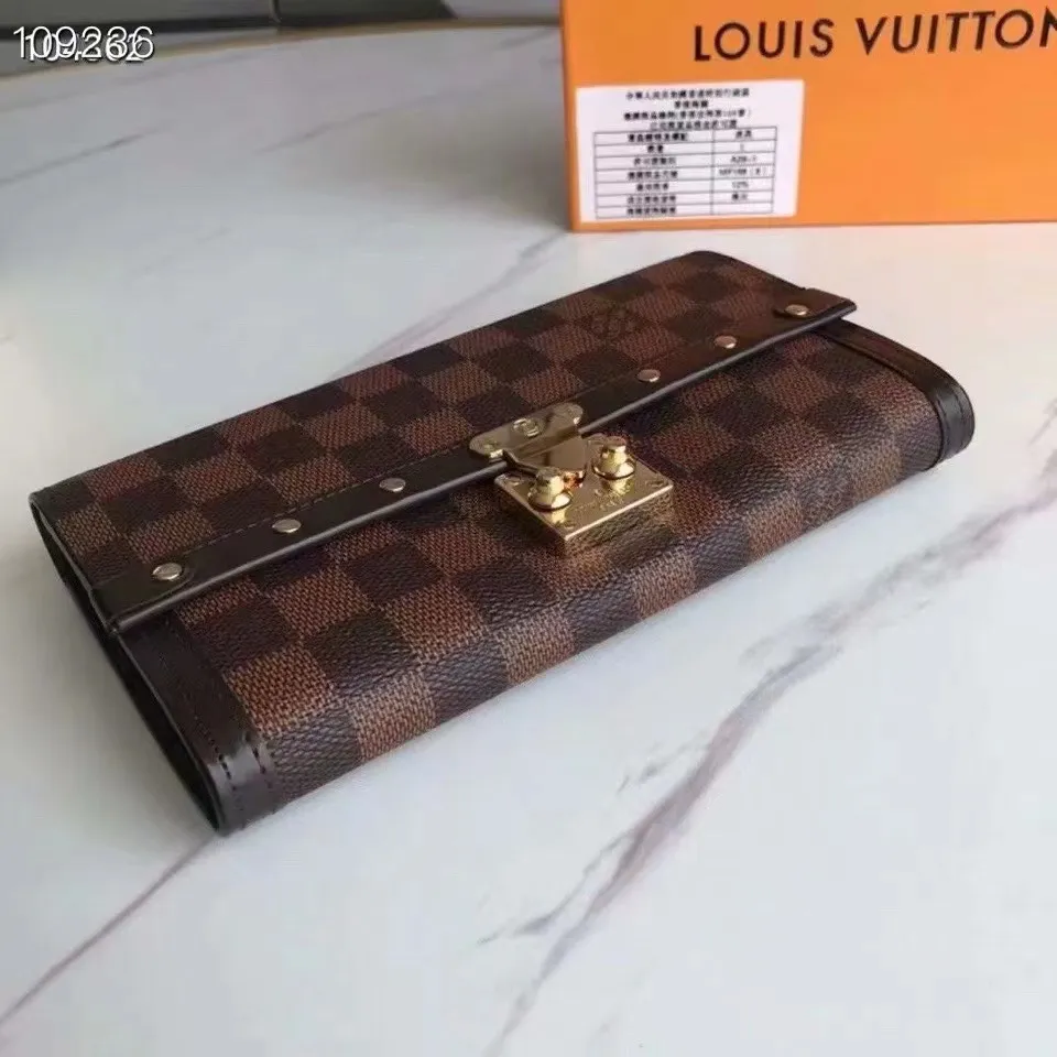 P160N60535 Material: PVC with cowhide leather Size: 21/10 Crafted from Damier Ebene canvas and decorated with the iconic S lock and rivets, this stylish Venice wallet pays homage to Louis Vuitton’s rich heritage as a luxury luggage manufacturer. Thanks to its spacious and functional interior, this model can also be used as an elegant clutch.