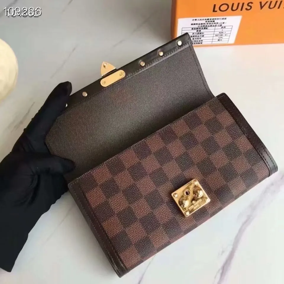 P160N60535 Material: PVC with cowhide leather Size: 21/10 Crafted from Damier Ebene canvas and decorated with the iconic S lock and rivets, this stylish Venice wallet pays homage to Louis Vuitton’s rich heritage as a luxury luggage manufacturer. Thanks to its spacious and functional interior, this model can also be used as an elegant clutch.
