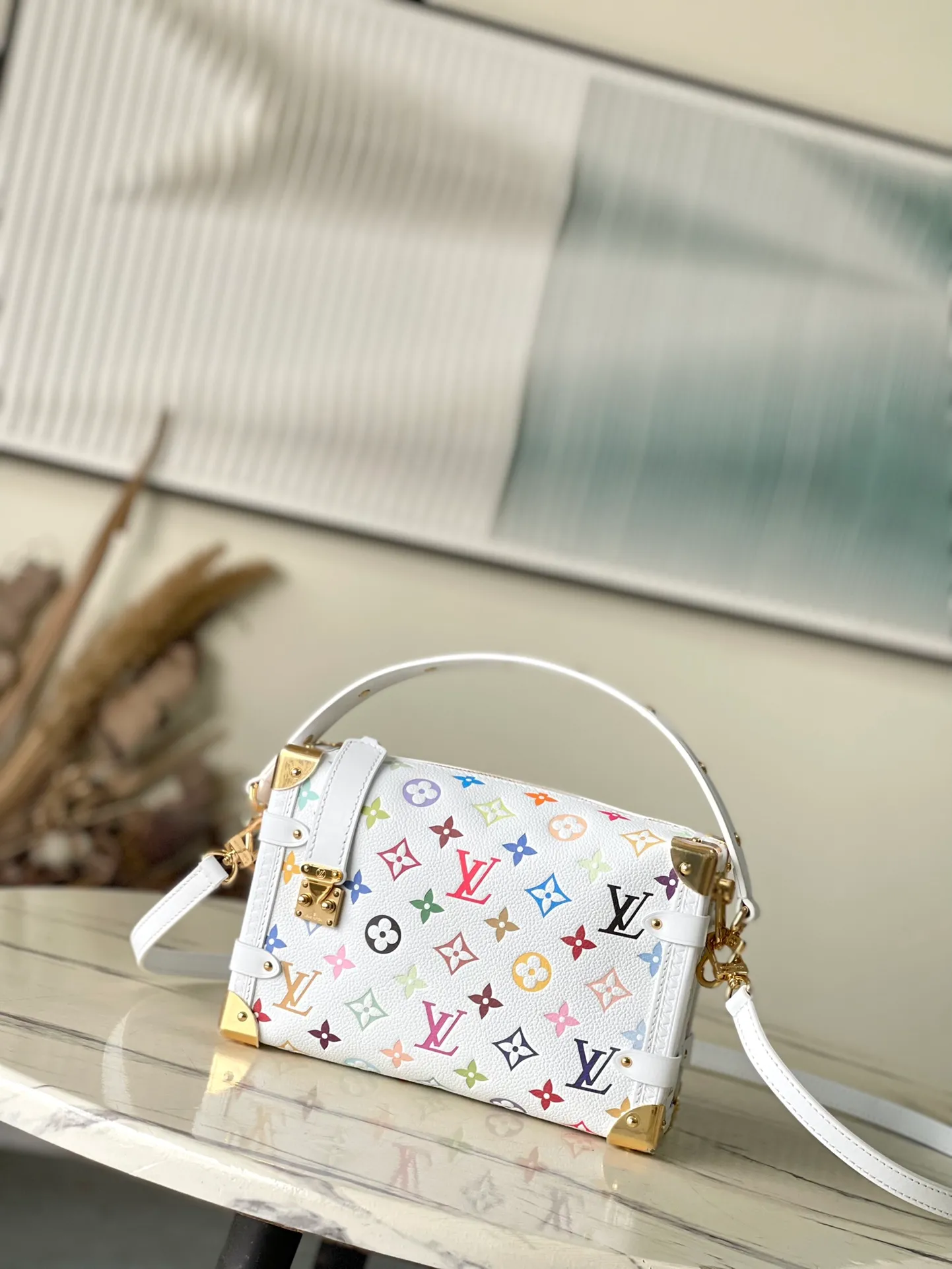 💰1300 (top-grain leather) Top original order M14046 This medium-sized Side Trunk handbag uses a humorous Monogram pattern to express the smart style of the x Murakami Takashi reissue series. It is made of soft cow leather with reinforced metal corners and the iconic S-lock lock, which can easily accommodate daily needs. The square shape is a nod to the brand's classic luggage, and the removable studded handle and shoulder strap allow for flexible carrying. Dimensions: 23.5 × 16 × 8.5 cm