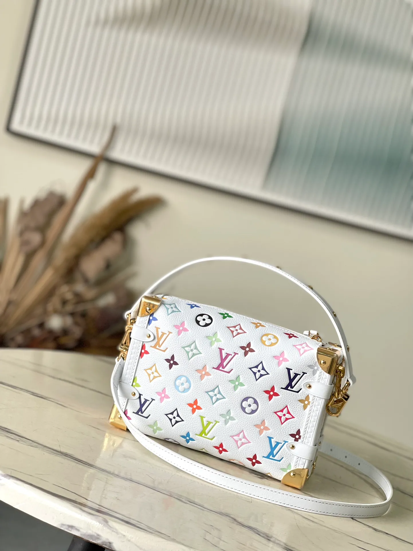 💰1300 (top-grain leather) Top original order M14046 This medium-sized Side Trunk handbag uses a humorous Monogram pattern to express the smart style of the x Murakami Takashi reissue series. It is made of soft cow leather with reinforced metal corners and the iconic S-lock lock, which can easily accommodate daily needs. The square shape is a nod to the brand's classic luggage, and the removable studded handle and shoulder strap allow for flexible carrying. Dimensions: 23.5 × 16 × 8.5 cm