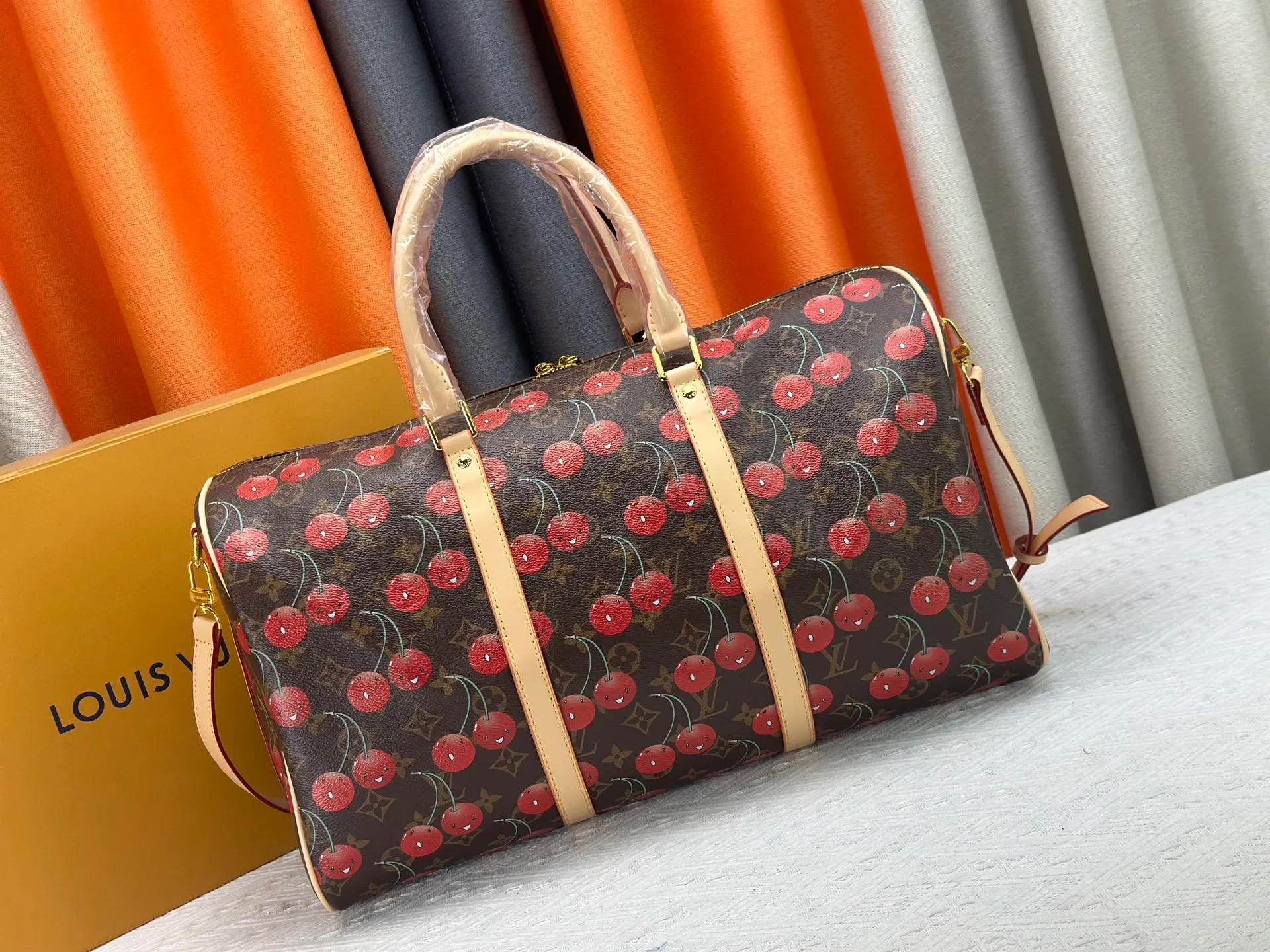P380 M13764 M41416 Keepall Bandoulière 45 travel bag gets a new look with the Louis Vuitton x Takashi Murakami retro series. Classic Monogram canvas features a patchwork pattern of sweet cherries and a bold lining that reflects the playful aesthetic of renowned Japanese artist Takashi Murakami. Side straps, top handles and adjustable shoulder straps reveal the natural color of the leather, while dazzling hardware completes the look.  27 x 20 x 45 cm (H x W x L) Carry-on dimensions Monogram coated canvas Cow leather trim Textile lining Metal hardware Double zipper closure Internal zip pocket Padlock Designer tag, hot stampable Shoulder strap: removable, adjustable Half-length strap: 36.0 cm Half-length strap adjustable to: 50.0 cm Handle: Double handle