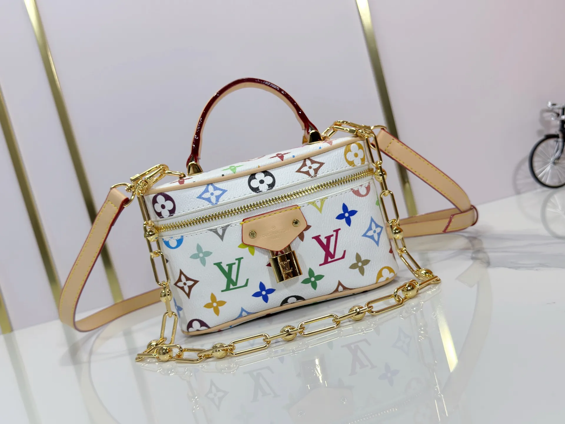 P280 Upgraded original M13662 This Vanity Pouch handbag is from the Louis Vuitton x Takashi Murakami reissue series, reinterpreting the brand's classic Monogram pattern with the artist's distinctive tones. Coated canvas is trimmed with calfskin, while a zipper closure, detachable chain and LV-engraved padlock add a metallic sheen. Dimensions: 11.5 x 6.5 x 19 cm (height x width x length)