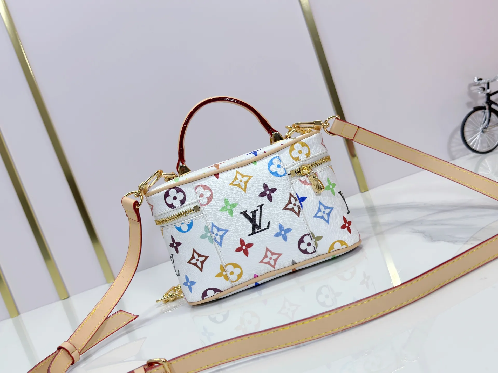 P280 Upgraded original M13662 This Vanity Pouch handbag is from the Louis Vuitton x Takashi Murakami reissue series, reinterpreting the brand's classic Monogram pattern with the artist's distinctive tones. Coated canvas is trimmed with calfskin, while a zipper closure, detachable chain and LV-engraved padlock add a metallic sheen. Dimensions: 11.5 x 6.5 x 19 cm (height x width x length)