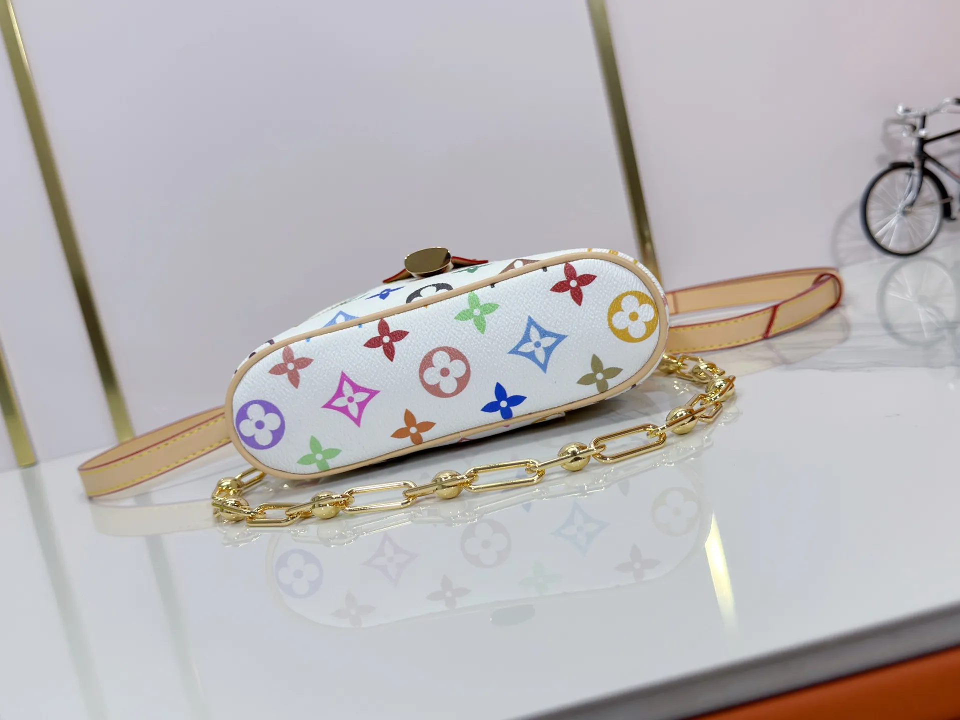 P280 Upgraded original M13662 This Vanity Pouch handbag is from the Louis Vuitton x Takashi Murakami reissue series, reinterpreting the brand's classic Monogram pattern with the artist's distinctive tones. Coated canvas is trimmed with calfskin, while a zipper closure, detachable chain and LV-engraved padlock add a metallic sheen. Dimensions: 11.5 x 6.5 x 19 cm (height x width x length)