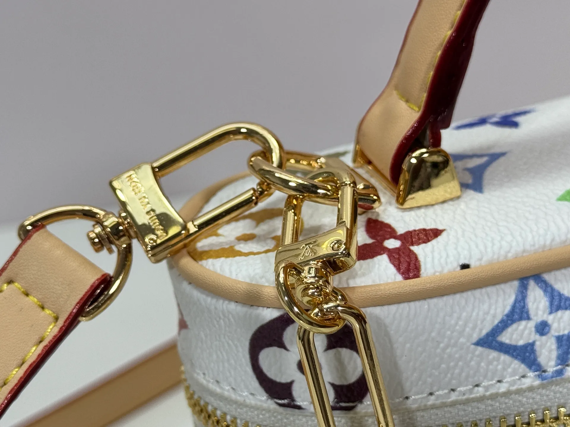 P280 Upgraded original M13662 This Vanity Pouch handbag is from the Louis Vuitton x Takashi Murakami reissue series, reinterpreting the brand's classic Monogram pattern with the artist's distinctive tones. Coated canvas is trimmed with calfskin, while a zipper closure, detachable chain and LV-engraved padlock add a metallic sheen. Dimensions: 11.5 x 6.5 x 19 cm (height x width x length)