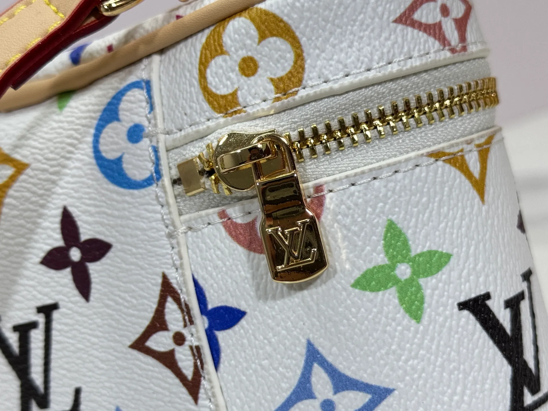 P280 Upgraded original M13662 This Vanity Pouch handbag is from the Louis Vuitton x Takashi Murakami reissue series, reinterpreting the brand's classic Monogram pattern with the artist's distinctive tones. Coated canvas is trimmed with calfskin, while a zipper closure, detachable chain and LV-engraved padlock add a metallic sheen. Dimensions: 11.5 x 6.5 x 19 cm (height x width x length)