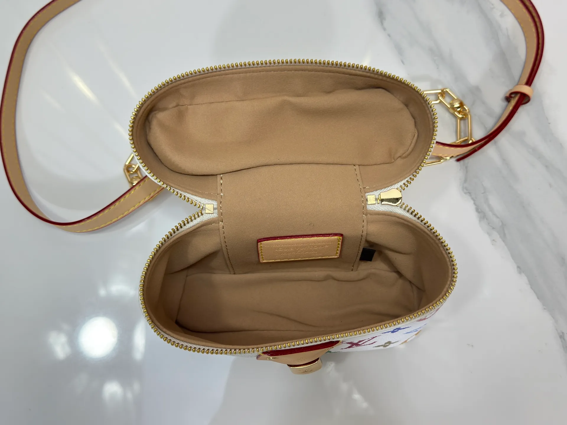 P280 Upgraded original M13662 This Vanity Pouch handbag is from the Louis Vuitton x Takashi Murakami reissue series, reinterpreting the brand's classic Monogram pattern with the artist's distinctive tones. Coated canvas is trimmed with calfskin, while a zipper closure, detachable chain and LV-engraved padlock add a metallic sheen. Dimensions: 11.5 x 6.5 x 19 cm (height x width x length)