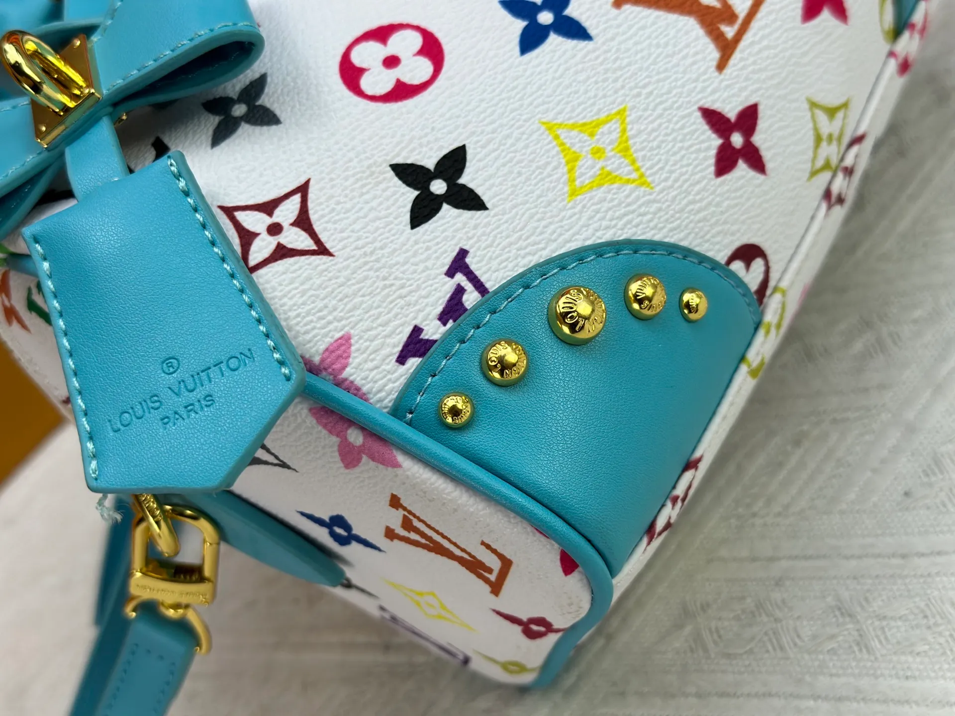 P260 upgraded original M58953 M46234 M46222 Speedy Bandoulière 20 handbag is made of soft coated canvas, and the full-length Monogram pattern is traced in colorful rainbow tones, highlighting the smart style of the Louis Vuitton x Murakami reissue series. The Toron handle and detachable shoulder strap are constructed of cow leather, the metal corners recall classic luggage elements, and the bow-shaped key bag and padlock add brand touches. Dimensions: 20.5 x 13.5 x 12.0 cm (length x height x width)