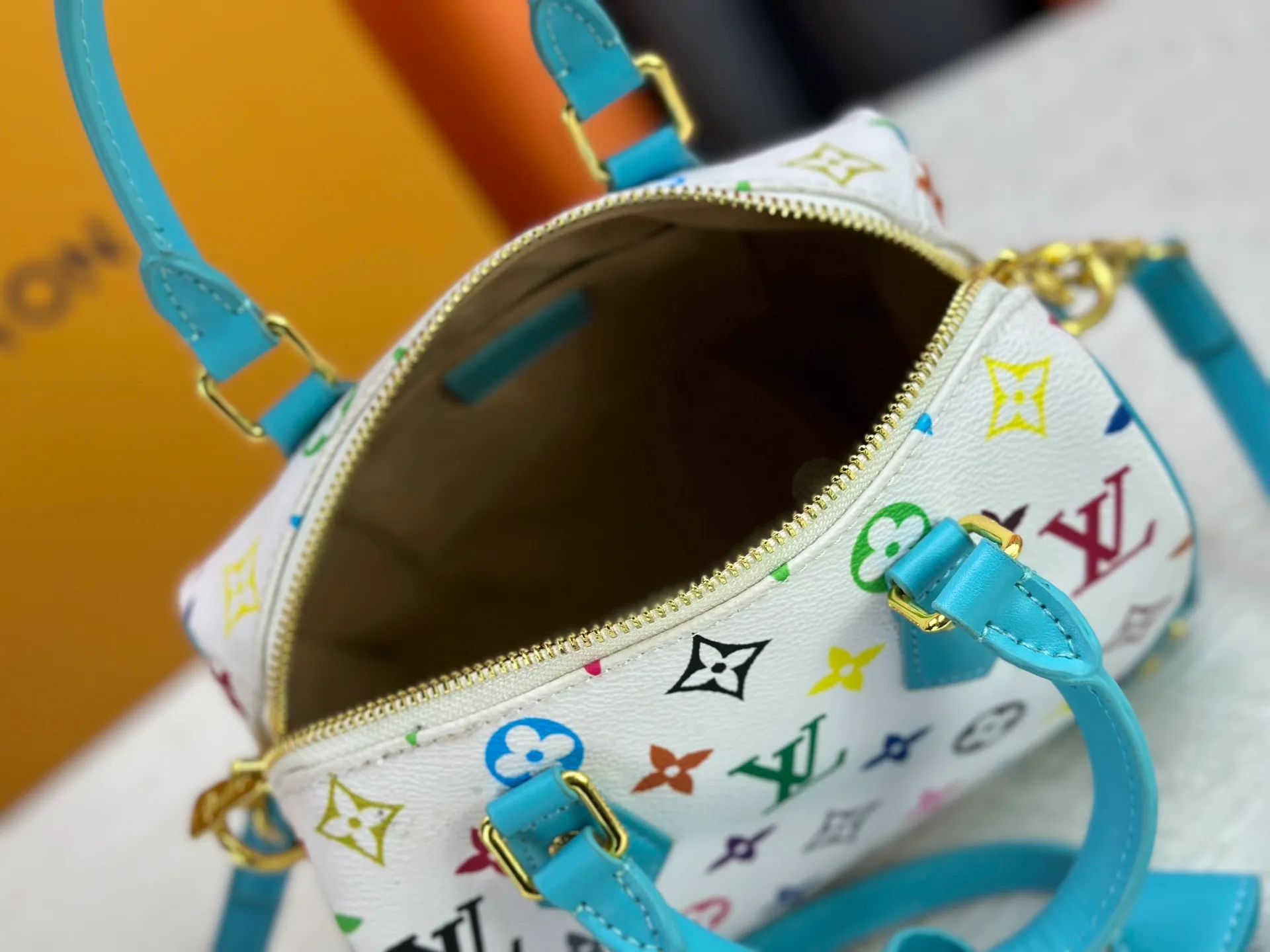 P260 upgraded original M58953 M46234 M46222 Speedy Bandoulière 20 handbag is made of soft coated canvas, and the full-length Monogram pattern is traced in colorful rainbow tones, highlighting the smart style of the Louis Vuitton x Murakami reissue series. The Toron handle and detachable shoulder strap are constructed of cow leather, the metal corners recall classic luggage elements, and the bow-shaped key bag and padlock add brand touches. Dimensions: 20.5 x 13.5 x 12.0 cm (length x height x width)