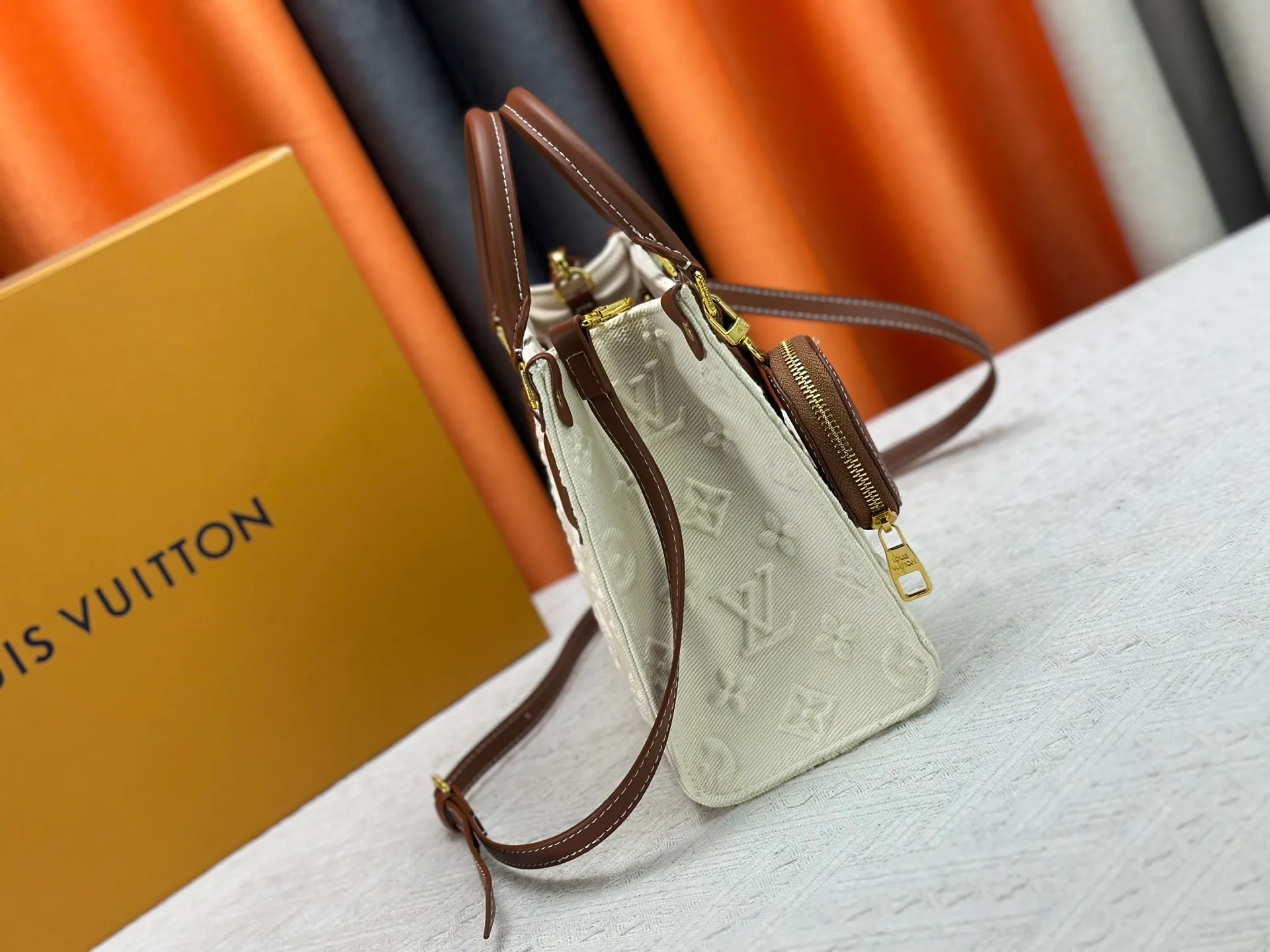 P300 M45659 M46373 Apricot embossed denim OnTheGo small new version The legendary ONTHEGO handbag: made of washed LV Blason denim, with deep tones to accentuate the gradient effect of the LV letters, showing Pharrell Williams' creative ingenuity in translating graceful music into fashion language. The zippered front pocket provides easy access to everyday items, while the drawstring closure and magnetic laces provide ample space. Detailed features25x11x19 cm