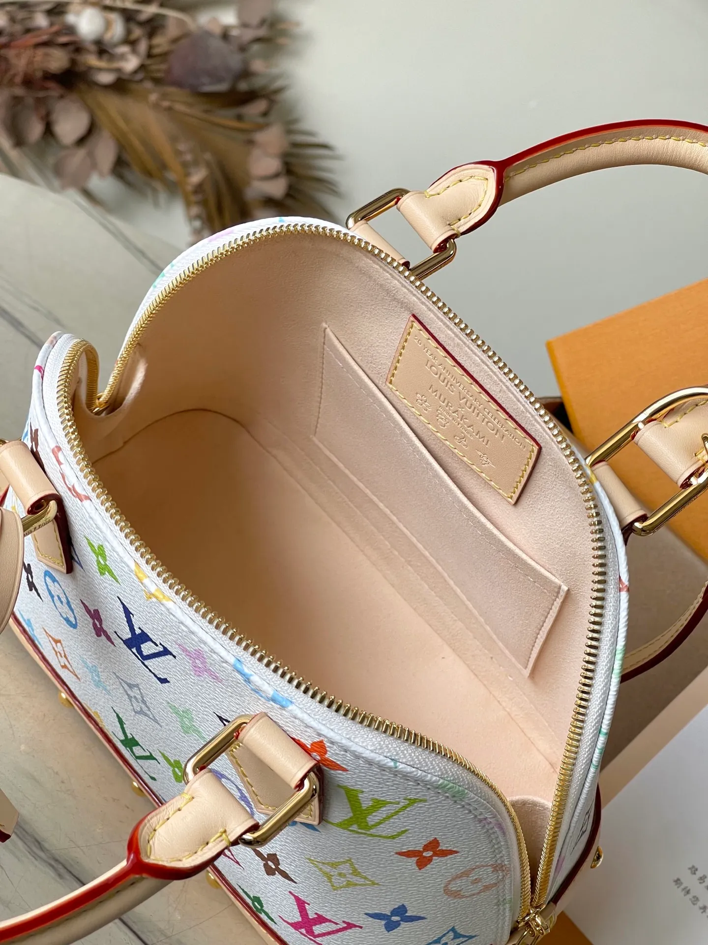 💰1080 Top original order M13078 This AmaBB handbag is filled with the joyful style of the Louis Vuitton x Murakami collaboration series, cleverly recalling the Art Deco style design of the 1930s. Monogram coated canvas is dyed in Murakami’s playful tones, and classic cow leather elements are incorporated into the Toron handle, bag base, detachable shoulder strap and LVxTM key bag. Dimensions: 23.5 × 17.5 × 11.5 cm