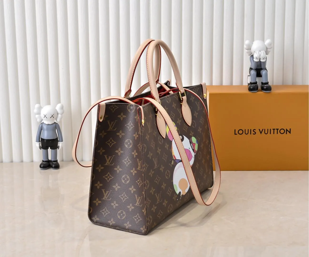 Batch 320💰M45039 M13668!🔥Lv&Takashi Murakami🐼Panda print OnTheGo new version The legendary ONTHEGO handbag: always able to meet your various needs for handbags. It has a large capacity but is not bulky. It is stiff and soft to the touch, making it suitable for home and travel. Tighten the side ties and it instantly transforms into a stylish urban handbag. Loosen the straps and it transforms into a chic and practical handbag. The slender leather handle can be carried over the shoulder or between the arms. The model shown here is made of Damier Azur canvas. Size: 35x27x14cm