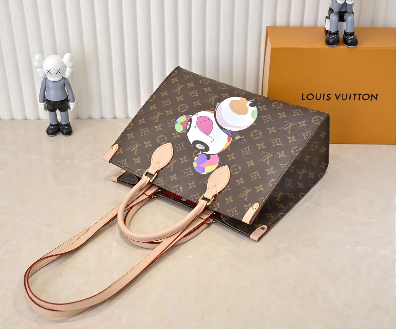 Batch 320💰M45039 M13668!🔥Lv&Takashi Murakami🐼Panda print OnTheGo new version The legendary ONTHEGO handbag: always able to meet your various needs for handbags. It has a large capacity but is not bulky. It is stiff and soft to the touch, making it suitable for home and travel. Tighten the side ties and it instantly transforms into a stylish urban handbag. Loosen the straps and it transforms into a chic and practical handbag. The slender leather handle can be carried over the shoulder or between the arms. The model shown here is made of Damier Azur canvas. Size: 35x27x14cm