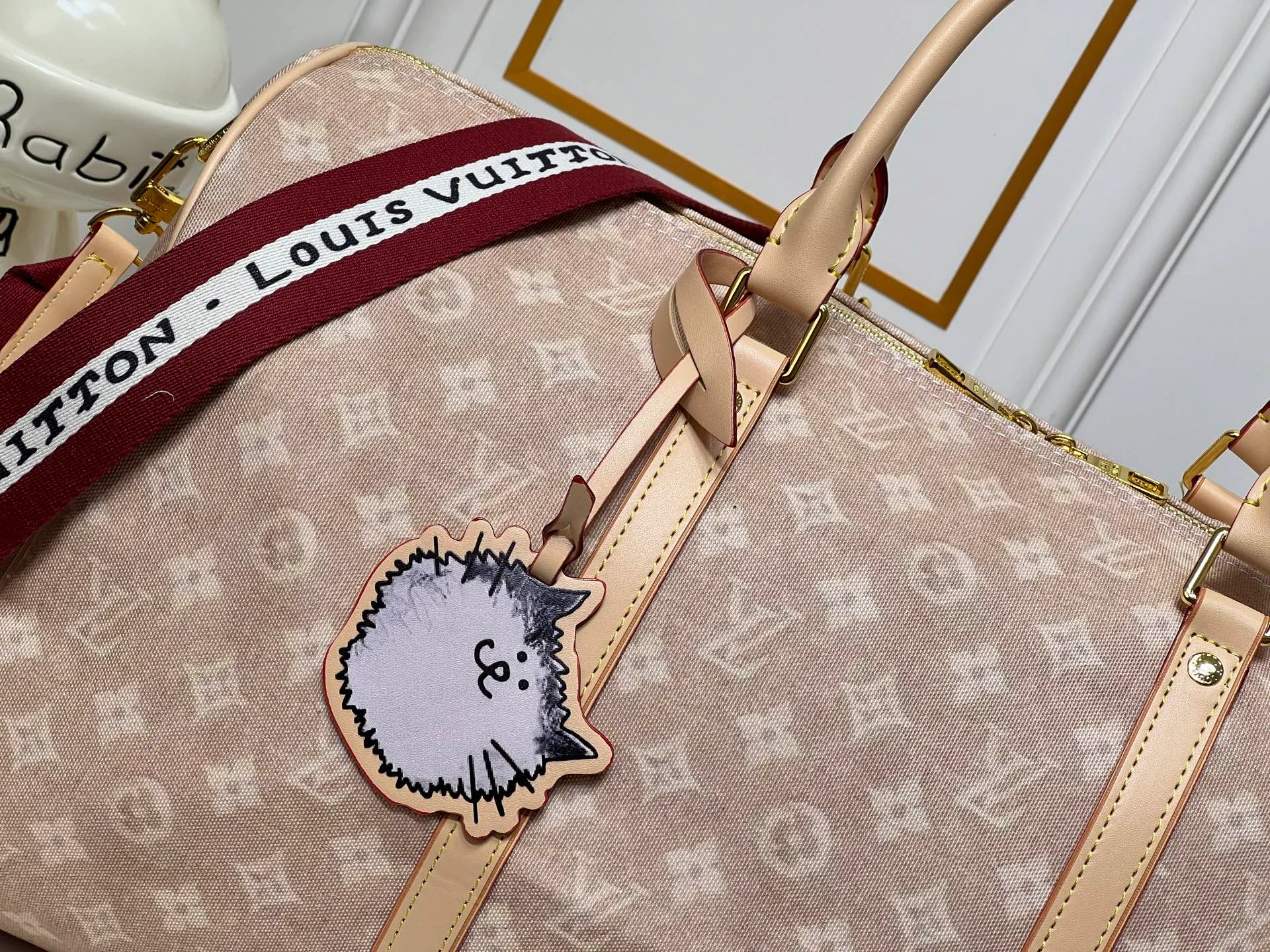 Batch 420💰M25787 This Keepall Bandouliere 45 travel bag is from the Travel With series presented by Louis Vuitton in collaboration with Grace Coddington. It uses Meowgram canvas to interpret the Monogram pattern in a playful reimagining, looking back to the hard suitcase inspiration of the 1900s. The cute cat-shaped branding adds smart touches, and the detachable and adjustable shoulder strap is embellished with the handwritten brand logo. Size: 45x27x20cm