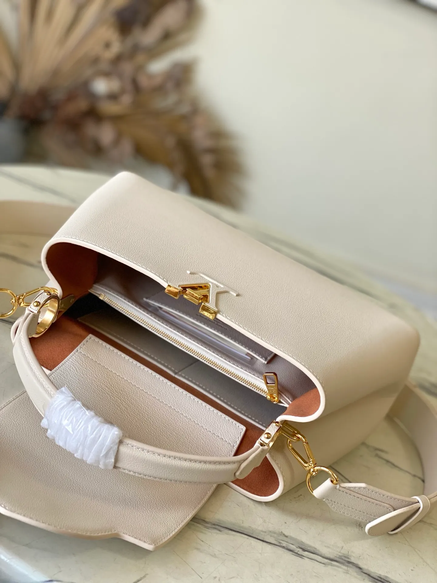 💰2360 "Special Original Leather" M14979 off-white Capucines Souple medium handbag is made of fine grained cow leather, with a sharp contrast of suede lining and dazzling metal parts, and uses the LV letters to express the brand heritage. The flip cover can be folded in or out, and the compartments and pockets can store your daily needs in an orderly manner, and you can switch between various carrying methods at will. 33.0 x 24.0 x 12.0 cm