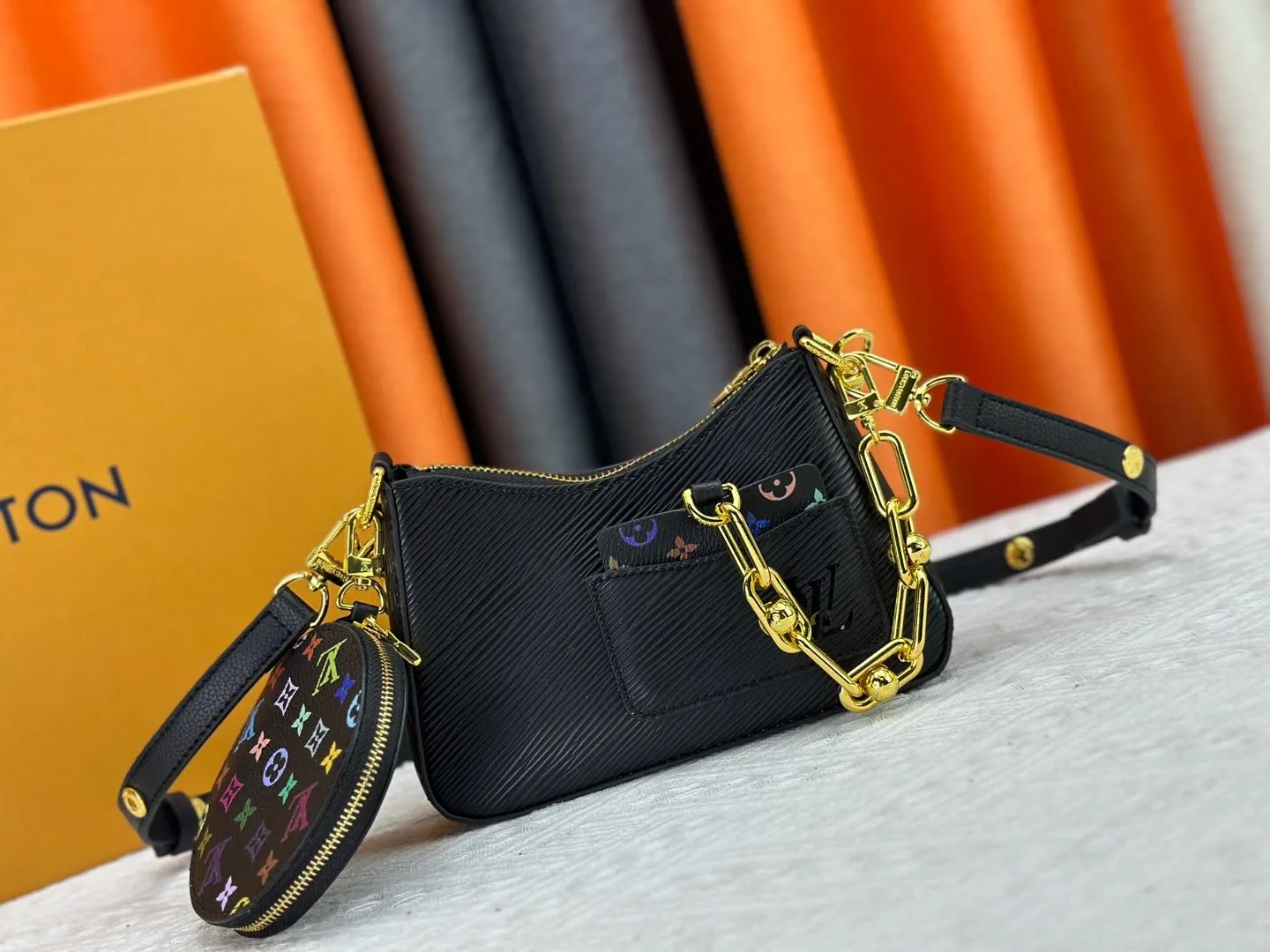 P260 M13099 This Marellini handbag is made of rich-texture Epi leather to create a delicate structure with ample space to store daily necessities such as smartphones. The round coin purse and mirror are both made of the colorful Monogram canvas from the Louis Vuitton x Takashi Murakami collaboration series, and are fixed to the bag body with a rough metal chain. Size: 19x13.5x6.5cm