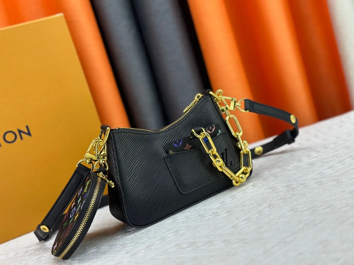 P260 M13099 This Marellini handbag is made of rich-texture Epi leather to create a delicate structure with ample space to store daily necessities such as smartphones. The round coin purse and mirror are both made of the colorful Monogram canvas from the Louis Vuitton x Takashi Murakami collaboration series, and are fixed to the bag body with a rough metal chain. Size: 19x13.5x6.5cm