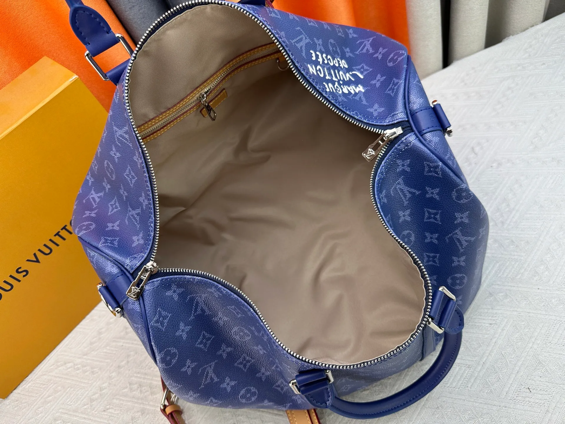 P340 Upgraded original M26864 M26865 M26866 This Keepall Bandoulière 50 travel bag is made of Monogram Heritage canvas dip-dyed in colorful colors, with cowhide trim, leather shoulder straps, removable leather nameplate and cotton lining. The Marque L.Vuitton Déposée logo pays homage to Louis Vuitton’s rich heritage.  29 x 23 x 50 cm (H x W x L) Monogram Heritage coated canvas Cow leather trim Textile lining Metal hardware Carry-on baggage dimensions Double zip closure Padlock Removable name tag Internal zip pocket Handles: Double handles