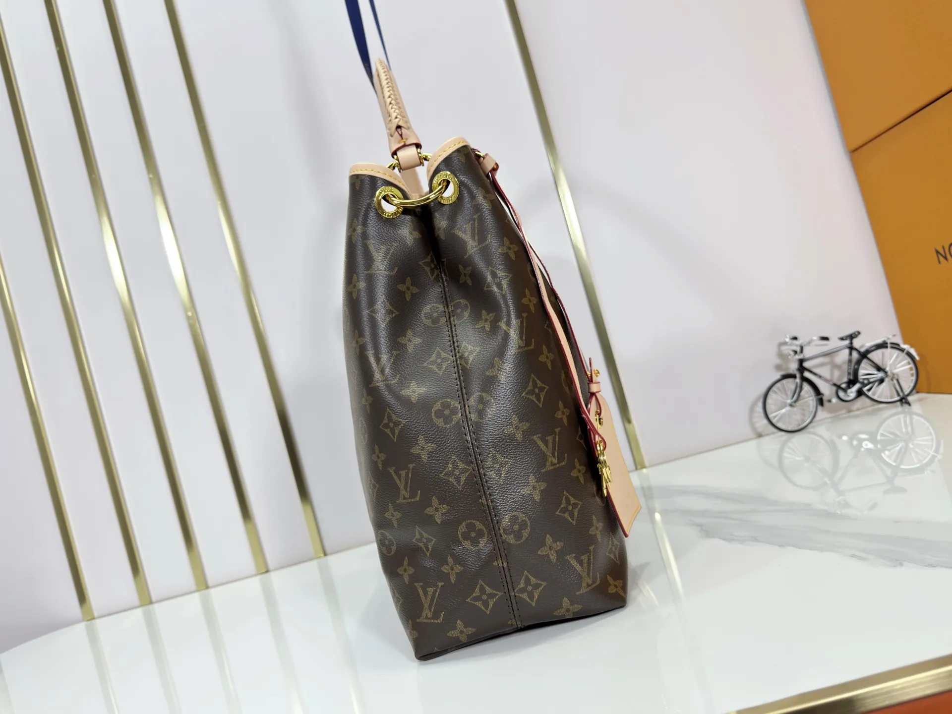 P280 upgrades the original M25877 Again handbag, a new interpretation of the iconic Artsy design first launched in 2010, now more flexible, more iconic and more refined. Rooted in LV’s DNA, this bag pays homage to Louis Vuitton’s craftsmanship with its classic Monogram canvas base, hand-woven handles and customizable name tag. It's spacious enough to hold a laptop and opens to reveal multiple pockets. Gold hooks can be used to hang playful accessories! ! Size:50x30x15.5CM