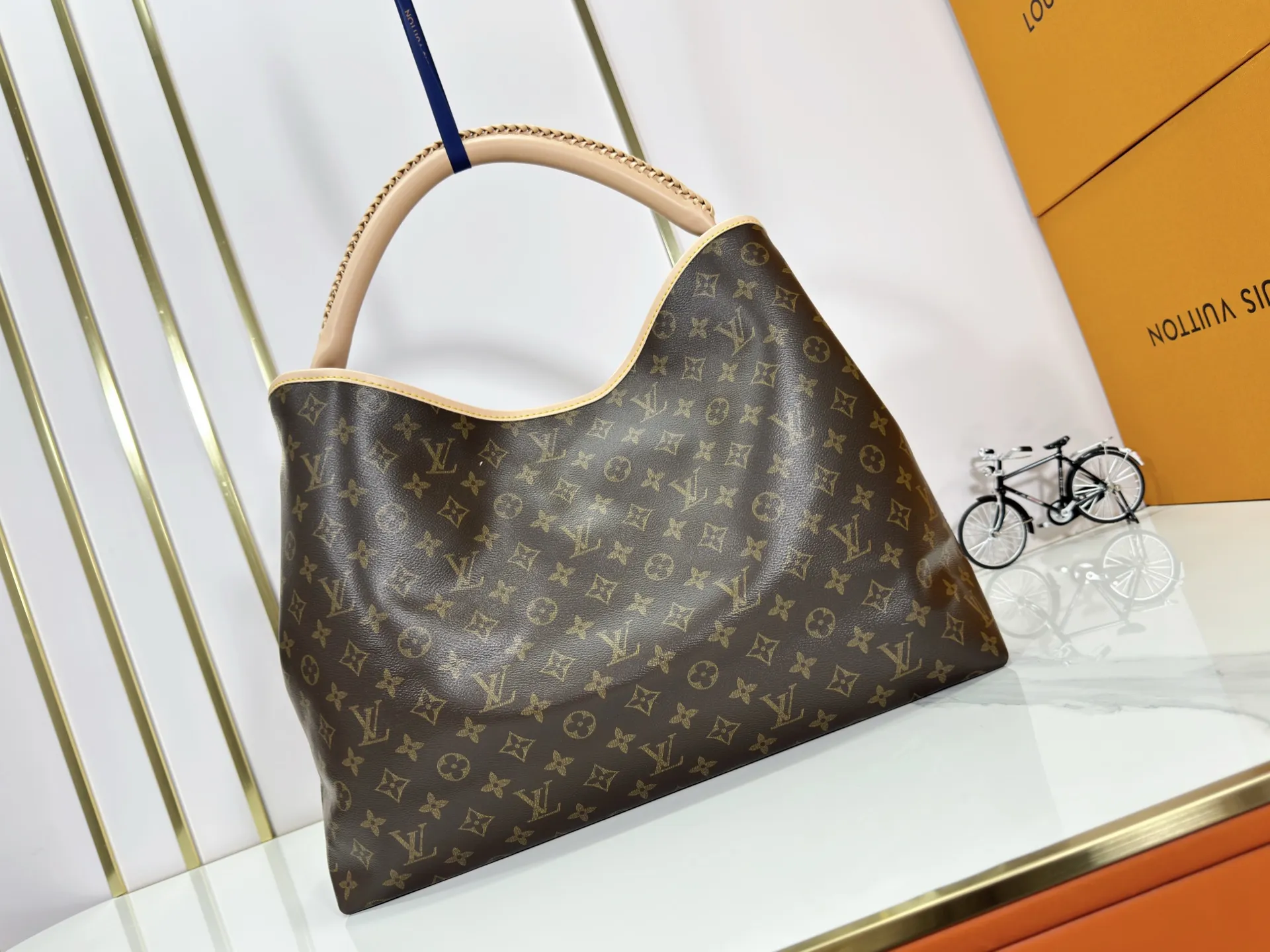 P280 upgrades the original M25877 Again handbag, a new interpretation of the iconic Artsy design first launched in 2010, now more flexible, more iconic and more refined. Rooted in LV’s DNA, this bag pays homage to Louis Vuitton’s craftsmanship with its classic Monogram canvas base, hand-woven handles and customizable name tag. It's spacious enough to hold a laptop and opens to reveal multiple pockets. Gold hooks can be used to hang playful accessories! ! Size:50x30x15.5CM