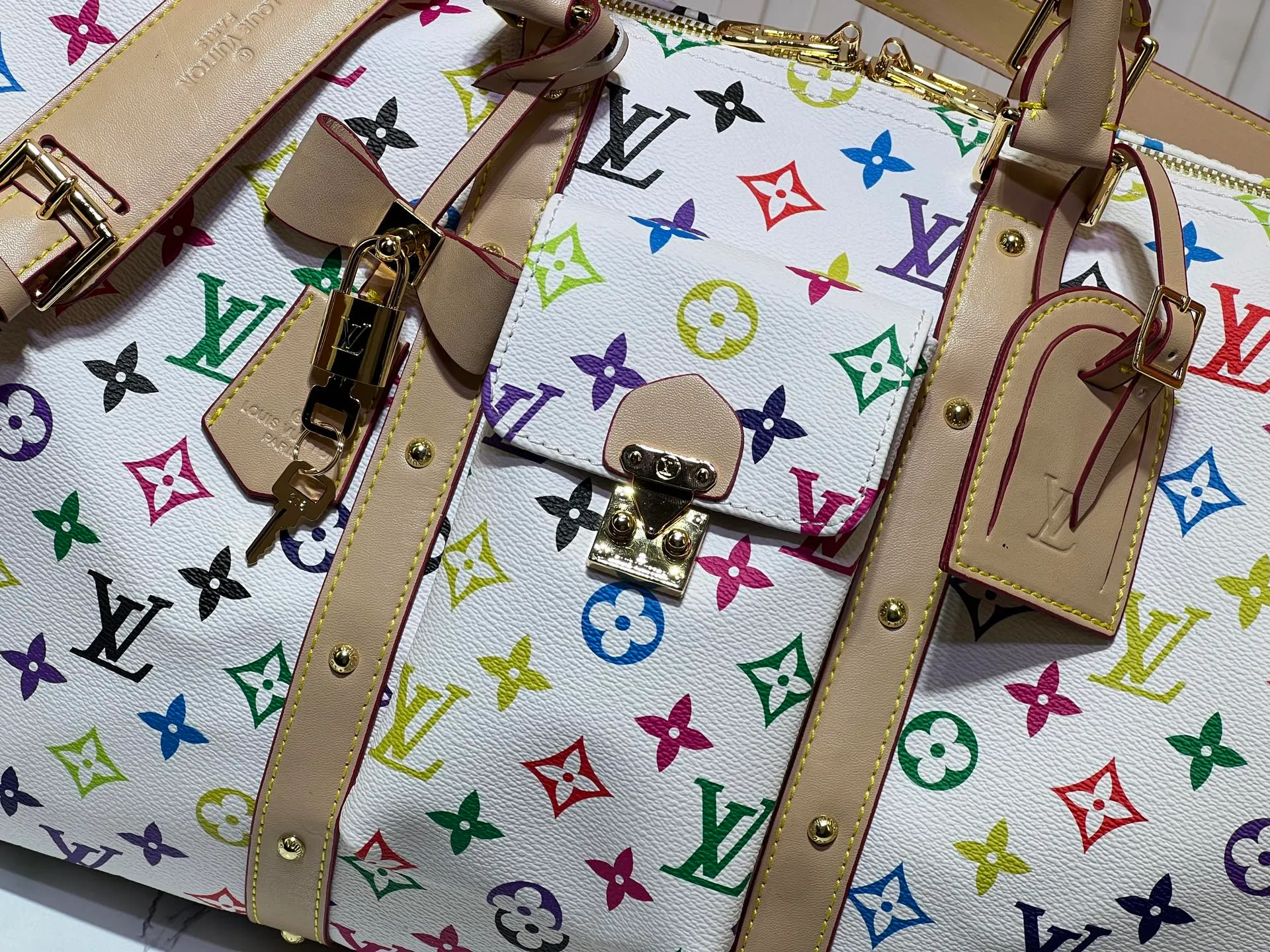 Batch 520💰 M13742 white color black color travel bag new season LV x TM KEEPALL BANDOULIÈRE 45 travel bag This Keepall Bandoulière 45 Jh travel bag is from the Louis Vuitton The S-lock buckle and glossy metal corners on the front pocket establish a classic foundation, while the rivet ribbon and bow-shaped key bag highlight the new season trend. 27 x 20 x 45 cm.