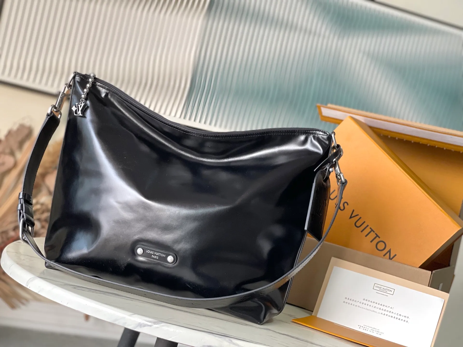 💰1380 (top-grain leather) top original order M13986 This Vagabond Hobo handbag is made of glossy soft cow leather to create an ergonomic and close-fitting silhouette. Whether it is carried cross-body or on the shoulder, it can show its cool style. The metal zipper enables smooth opening and closing, and the bead chain cleverly connects the zipper puller and V letter decoration. Dimensions: 35×12×38 cm