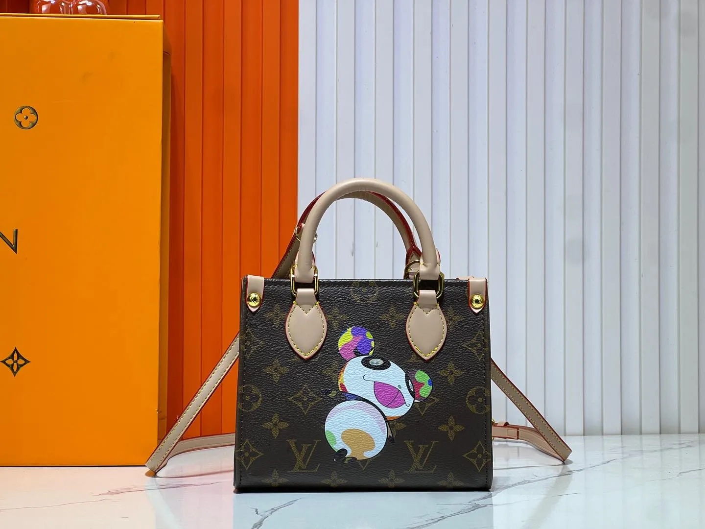 Batch 260💰M46993 M13668!🔥Lv&Takashi Murakami🐼Panda print OnTheGo BB new version The legendary ONTHEGO handbag: always able to meet your various needs for handbags. It has a large capacity but is not bulky. It is stiff and soft to the touch, making it suitable for home and travel. Tighten the side ties and it instantly transforms into a stylish urban handbag. Loosen the straps and it transforms into a chic and practical handbag. The slender leather handle can be carried over the shoulder or between the arms. The model shown here is made of Damier Azur canvas. Size: 18x15x8.5cm