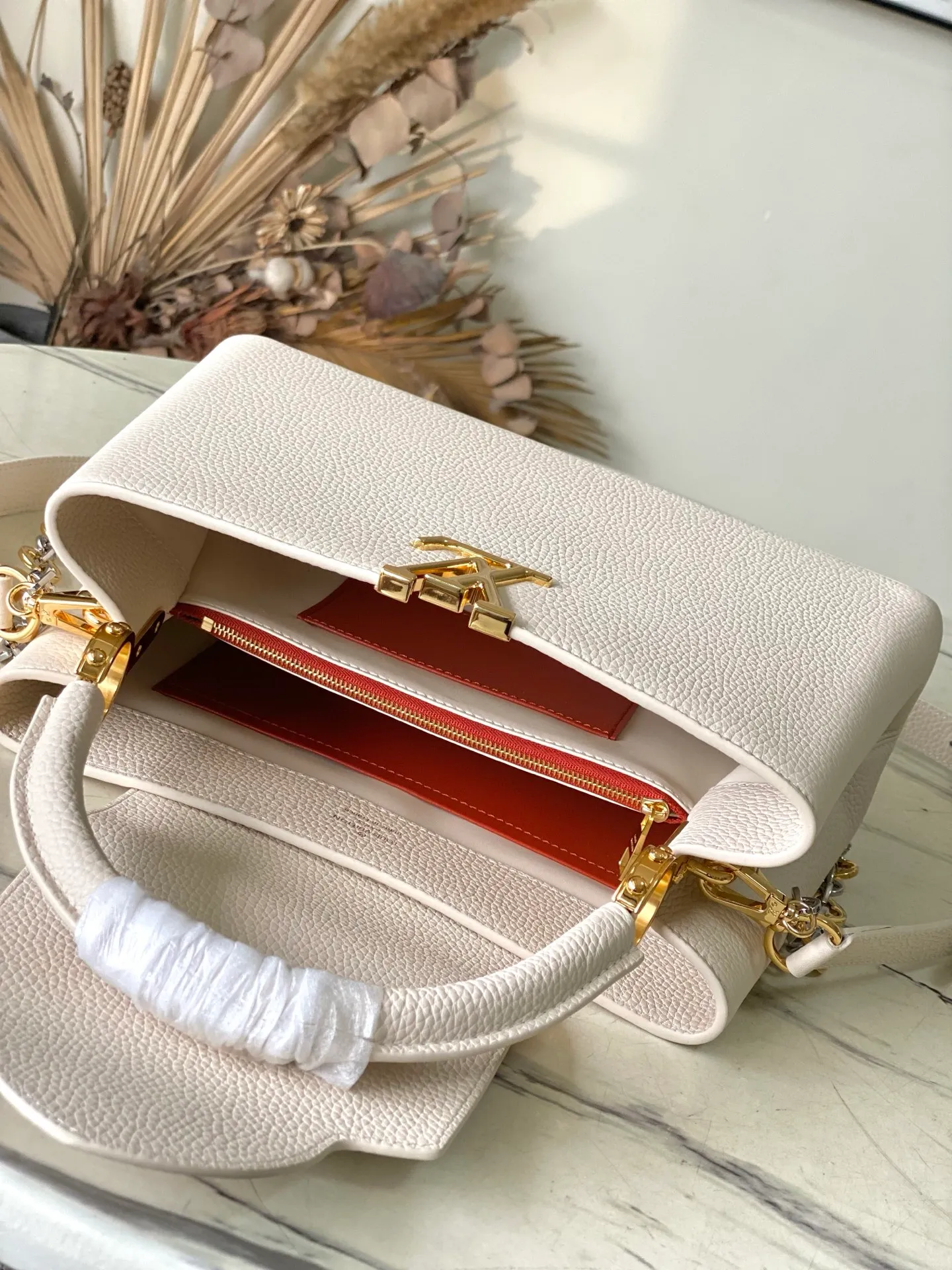 💰2480 "Special Grade Original Leather" M12935 Milk White Medium This Capucines medium handbag is from the Chain On You series. It uses Taurillon cow leather to focus on the brand's ingenuity and sophisticated craftsmanship. The jewelry-style double-plated chain is embellished with Monogram flowers, and the rounded LV letters and metal parts add elegant touches. Whether worn cross-body, hand-carried or shoulder-carried, it can display elegant style. Dimensions: 31.5 × 20 × 11 cm