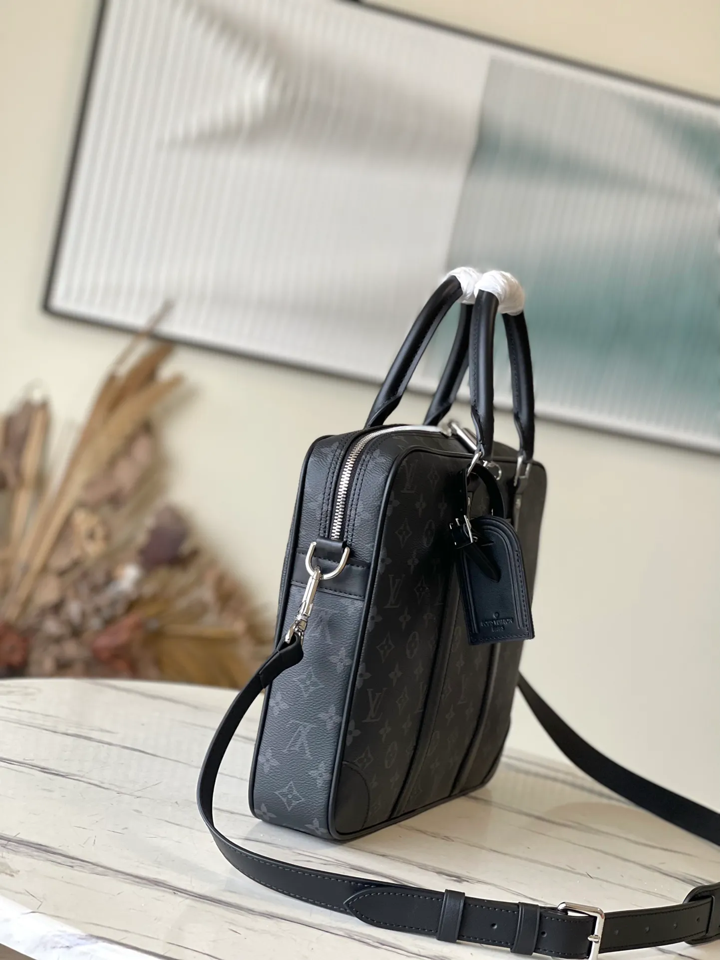 💰1000 Top Original M46457 This Voyage small briefcase is made of Damier Graphite coated canvas, with leather side straps, reinforced corners, top handles and nameplate. The outer pocket makes it easy to store a smartphone, the padded interior compartment holds a 13-inch laptop, and the removable and adjustable shoulder strap makes it comfortable to carry over the shoulder. Dimensions: 36.5 x 27.5 x 6 cm