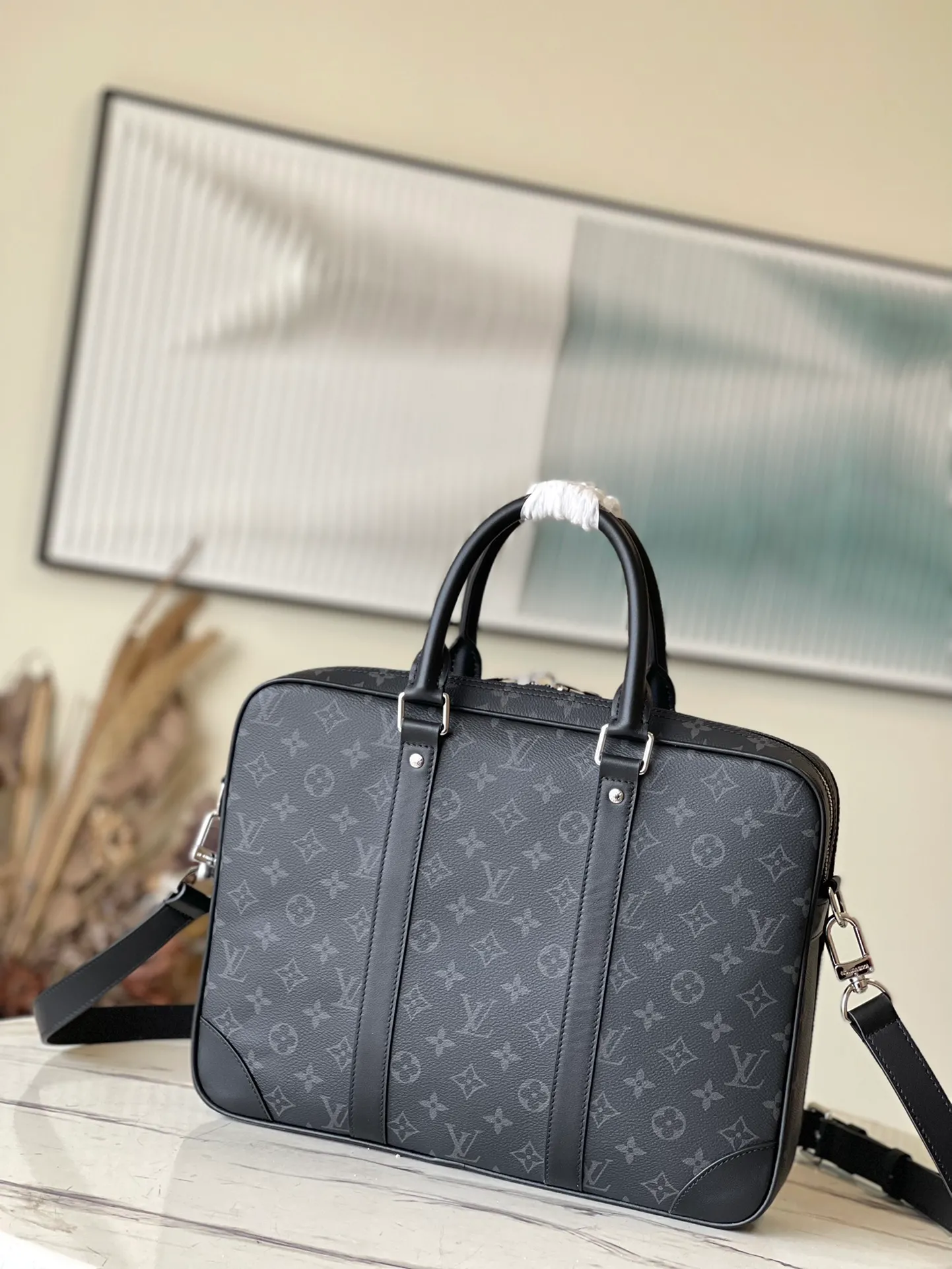 💰1000 Top Original M46457 This Voyage small briefcase is made of Damier Graphite coated canvas, with leather side straps, reinforced corners, top handles and nameplate. The outer pocket makes it easy to store a smartphone, the padded interior compartment holds a 13-inch laptop, and the removable and adjustable shoulder strap makes it comfortable to carry over the shoulder. Dimensions: 36.5 x 27.5 x 6 cm
