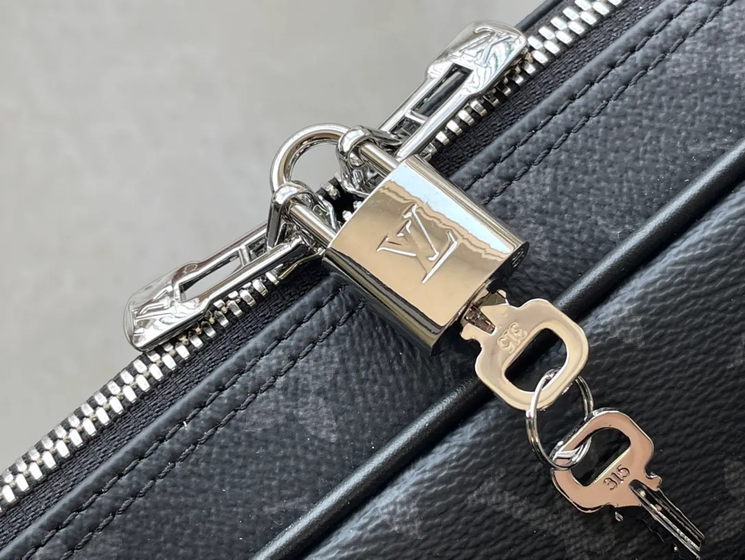 💰1000 Top Original M46457 This Voyage small briefcase is made of Damier Graphite coated canvas, with leather side straps, reinforced corners, top handles and nameplate. The outer pocket makes it easy to store a smartphone, the padded interior compartment holds a 13-inch laptop, and the removable and adjustable shoulder strap makes it comfortable to carry over the shoulder. Dimensions: 36.5 x 27.5 x 6 cm