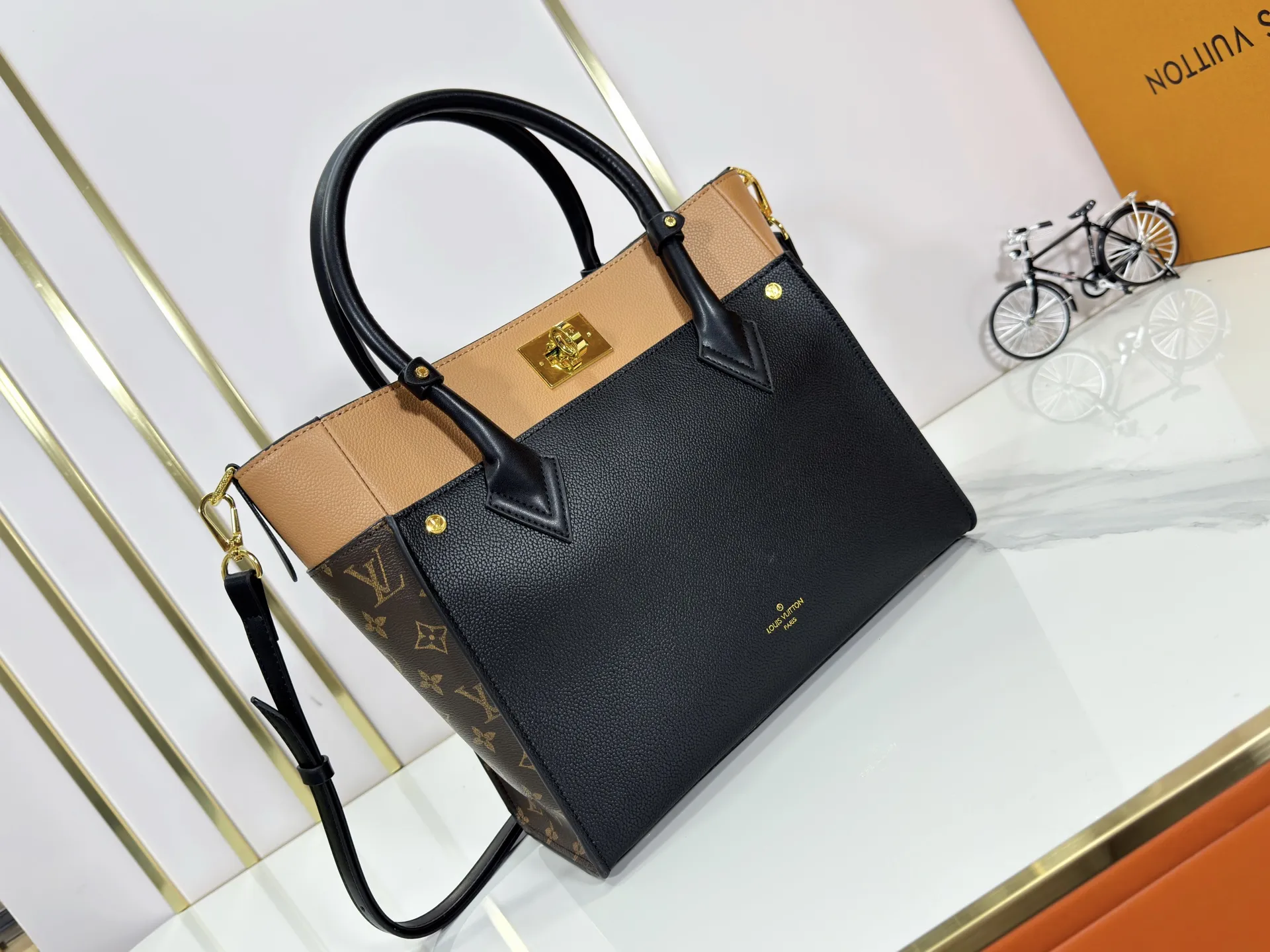 P360 upgraded original M53826 M53826 M53825 M53824 M53823On My Side handbag shows the elegant fusion of calfskin and classic Monogram canvas. Contrasting canvas shapes the large outer pocket, creating a trompe l'oeil effect as if two handbags merge into one. Plenty of space can easily accommodate office needs, and the adjustable shoulder strap allows for a cross-body style. Dimensions: 30.5 x 24.5 x 14 cm (Length x Height x Width) - Calfskin and Monogram coated canvas - Cowhide leather trim - Microfiber lining - 2 top handles for hand or elbow carry - Adjustable shoulder strap for shoulder or cross-body wear - Lock closure - 2 outer pockets with magnetic closure - Zip pocket - 1 patch pocket