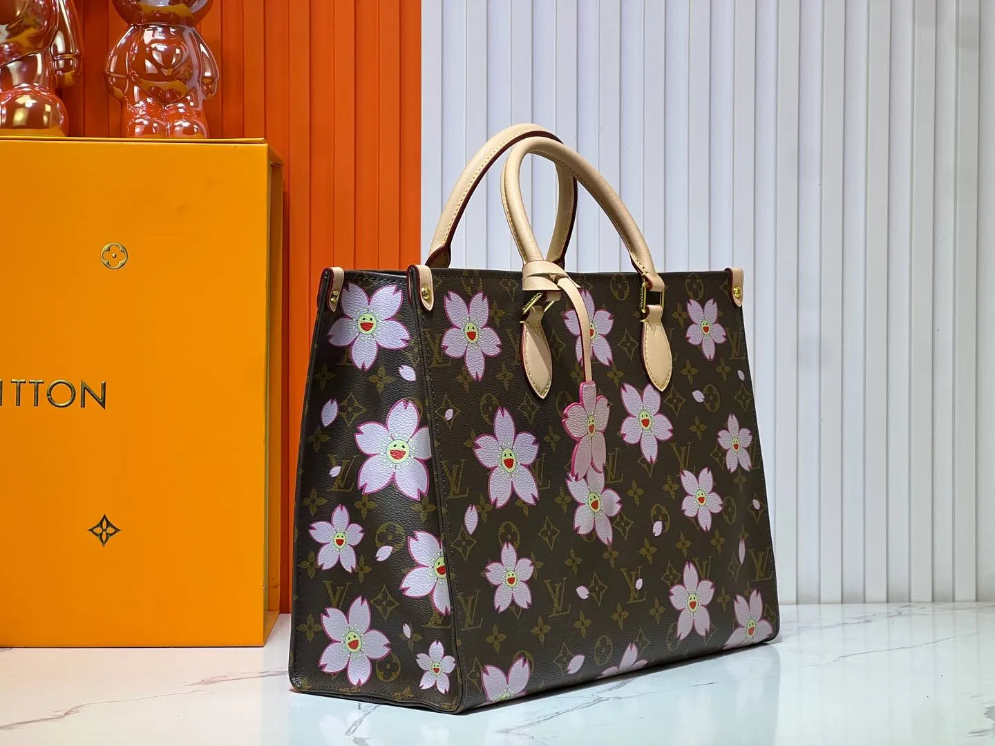 Batch 280💰M45039 M13668!🔥Lv&Takashi Murakami Sakura🌸OnTheGo new version The legendary ONTHEGO handbag: always able to meet your various needs for handbags. It has a large capacity but is not bulky. It is stiff and soft to the touch, making it suitable for home and travel. Tighten the side ties and it instantly transforms into a stylish urban handbag. Loosen the straps and it transforms into a chic and practical handbag. The slender leather handle can be carried over the shoulder or between the arms. The model shown here is made of Damier Azur canvas. Size: 35x27x14cm