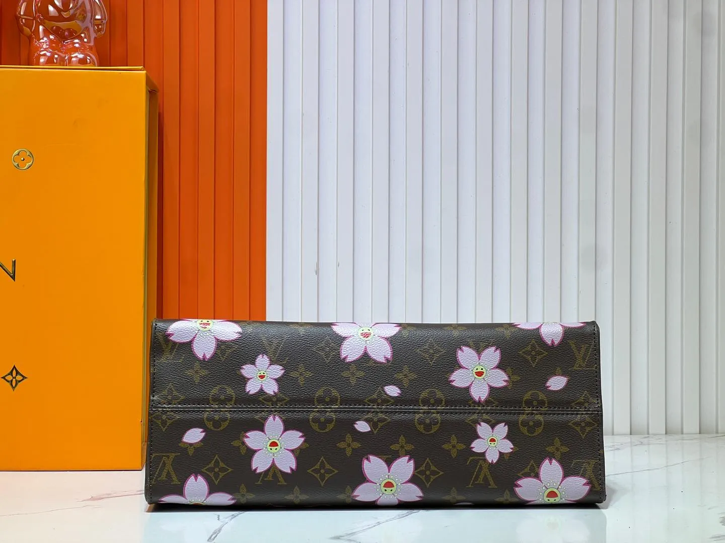 Batch 280💰M45039 M13668!🔥Lv&Takashi Murakami Sakura🌸OnTheGo new version The legendary ONTHEGO handbag: always able to meet your various needs for handbags. It has a large capacity but is not bulky. It is stiff and soft to the touch, making it suitable for home and travel. Tighten the side ties and it instantly transforms into a stylish urban handbag. Loosen the straps and it transforms into a chic and practical handbag. The slender leather handle can be carried over the shoulder or between the arms. The model shown here is made of Damier Azur canvas. Size: 35x27x14cm