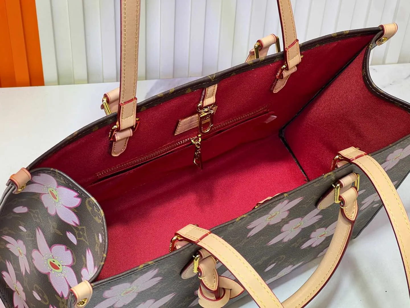Batch 280💰M45039 M13668!🔥Lv&Takashi Murakami Sakura🌸OnTheGo new version The legendary ONTHEGO handbag: always able to meet your various needs for handbags. It has a large capacity but is not bulky. It is stiff and soft to the touch, making it suitable for home and travel. Tighten the side ties and it instantly transforms into a stylish urban handbag. Loosen the straps and it transforms into a chic and practical handbag. The slender leather handle can be carried over the shoulder or between the arms. The model shown here is made of Damier Azur canvas. Size: 35x27x14cm