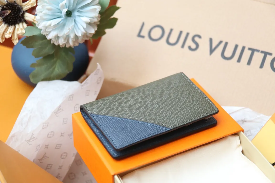 M30985 Pocket Wallet 💰260 This pocket wallet relies on exquisite inlay work to embed the V pattern into fine Taïga leather, echoing the traditional Louis Vuitton logo with bright colors. The slim structure hides plenty of space and can be easily stored in your pocket. 8 x 11 x 1 cm