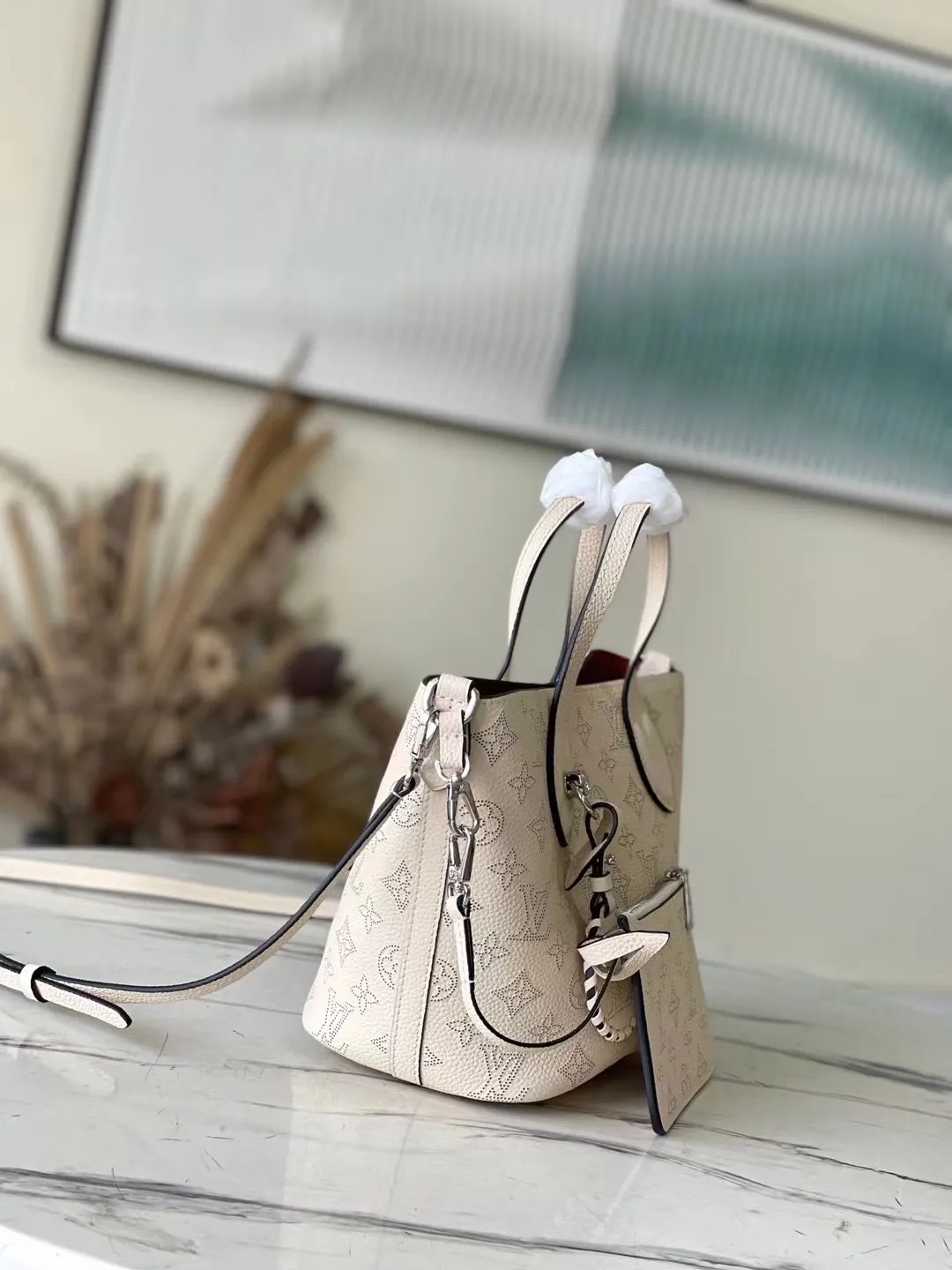 💰1060 (top layer leather) top original M21909 milky white Blossom small handbag is made of engraved and perforated cow leather, interpreting practical functions in a leisurely style. The inner compartment is equipped with a detachable zipper bag to easily accommodate daily needs; the handle is convenient for carrying by hand or elbow, and the detachable and adjustable shoulder strap adds shoulder and cross-body options. Dimensions: 20 x 20 x 12.5 cm