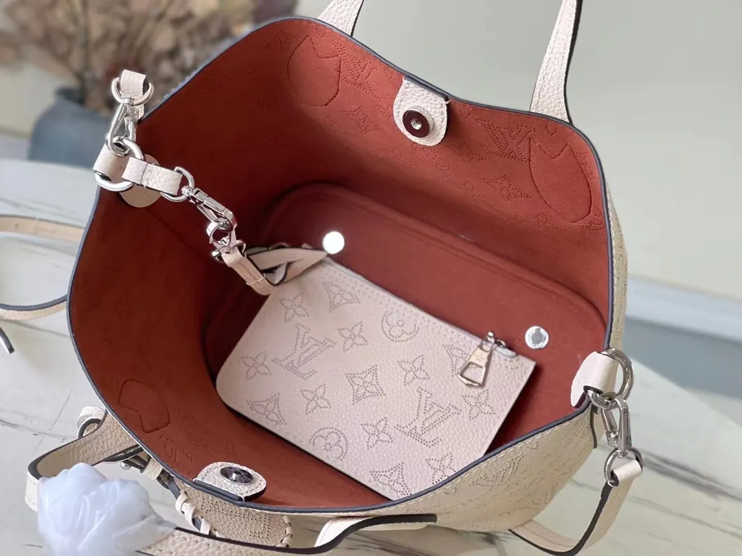 💰1060 (top layer leather) top original M21909 milky white Blossom small handbag is made of engraved and perforated cow leather, interpreting practical functions in a leisurely style. The inner compartment is equipped with a detachable zipper bag to easily accommodate daily needs; the handle is convenient for carrying by hand or elbow, and the detachable and adjustable shoulder strap adds shoulder and cross-body options. Dimensions: 20 x 20 x 12.5 cm