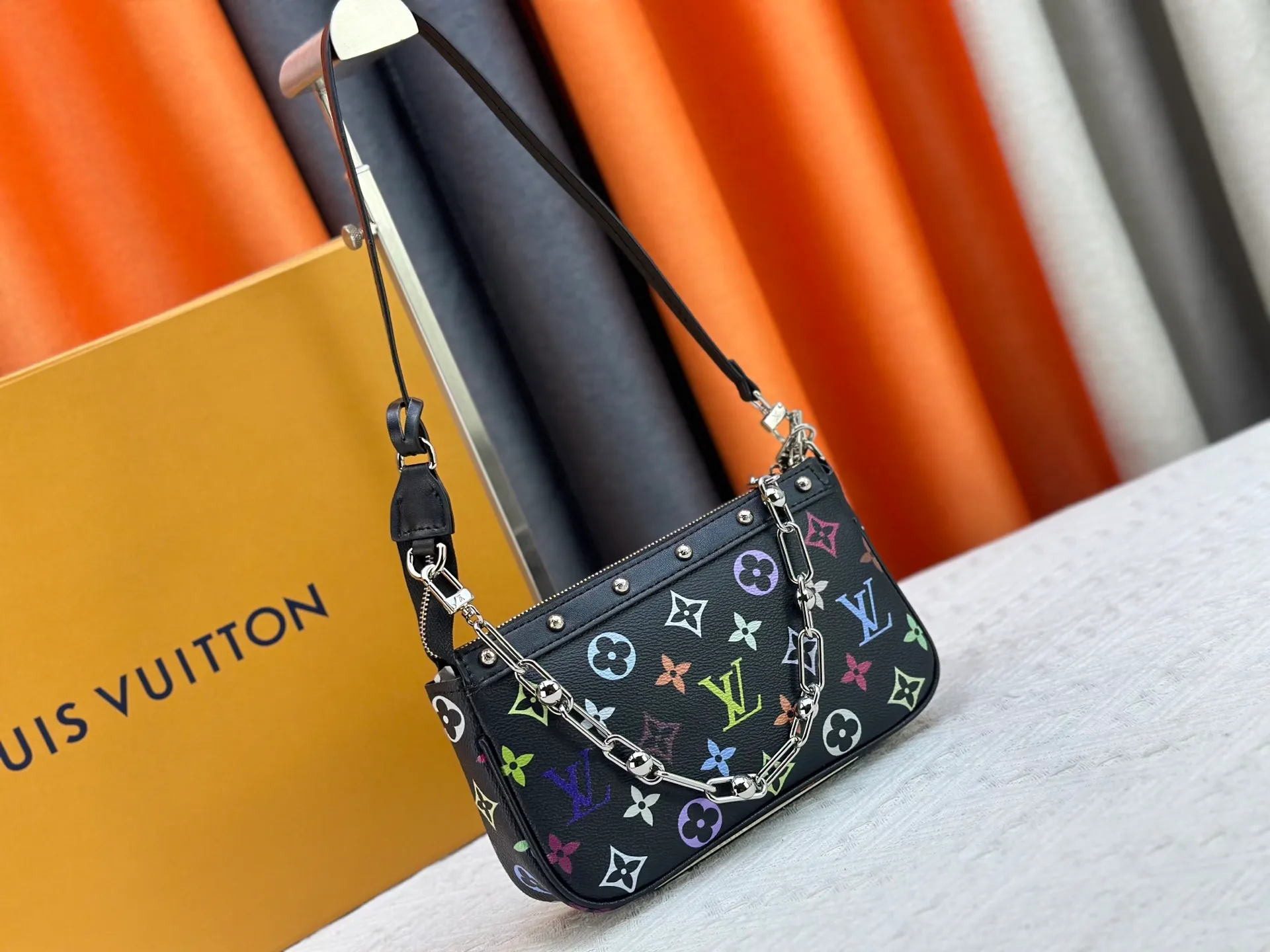 P220 M13404 M13663 Black color White color This Pochette Accessoires handbag is made of coated canvas, with colorful Monogram patterns to interpret the smart style of the Louis Vuitton × Murakami cross-border collaboration series. Calf leather trim and dazzling hardware add to the sophisticated details, while the detachable shoulder strap and chain provide flexible carry. Size: 22x13x4cm
