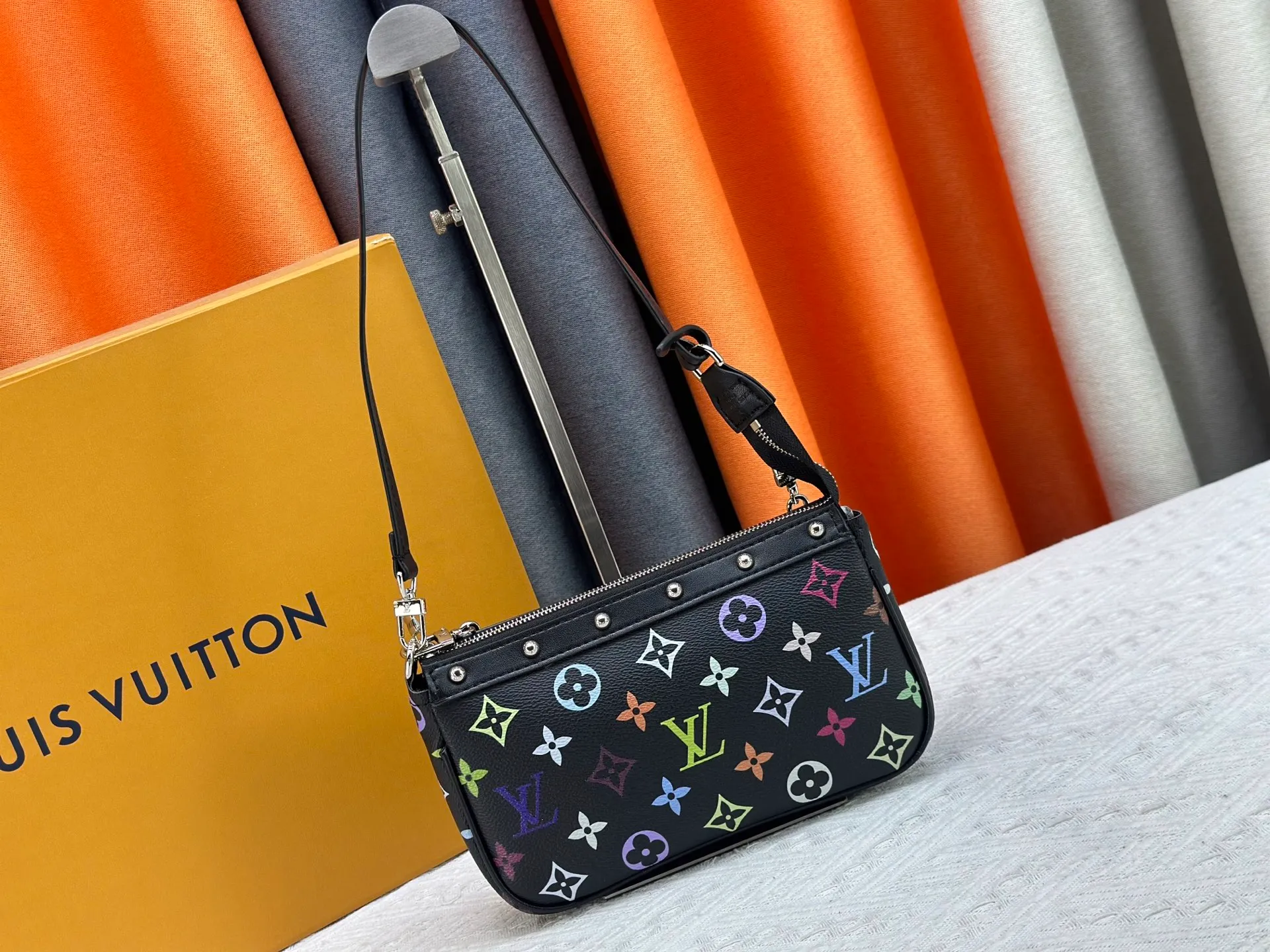 P220 M13404 M13663 Black color White color This Pochette Accessoires handbag is made of coated canvas, with colorful Monogram patterns to interpret the smart style of the Louis Vuitton × Murakami cross-border collaboration series. Calf leather trim and dazzling hardware add to the sophisticated details, while the detachable shoulder strap and chain provide flexible carry. Size: 22x13x4cm