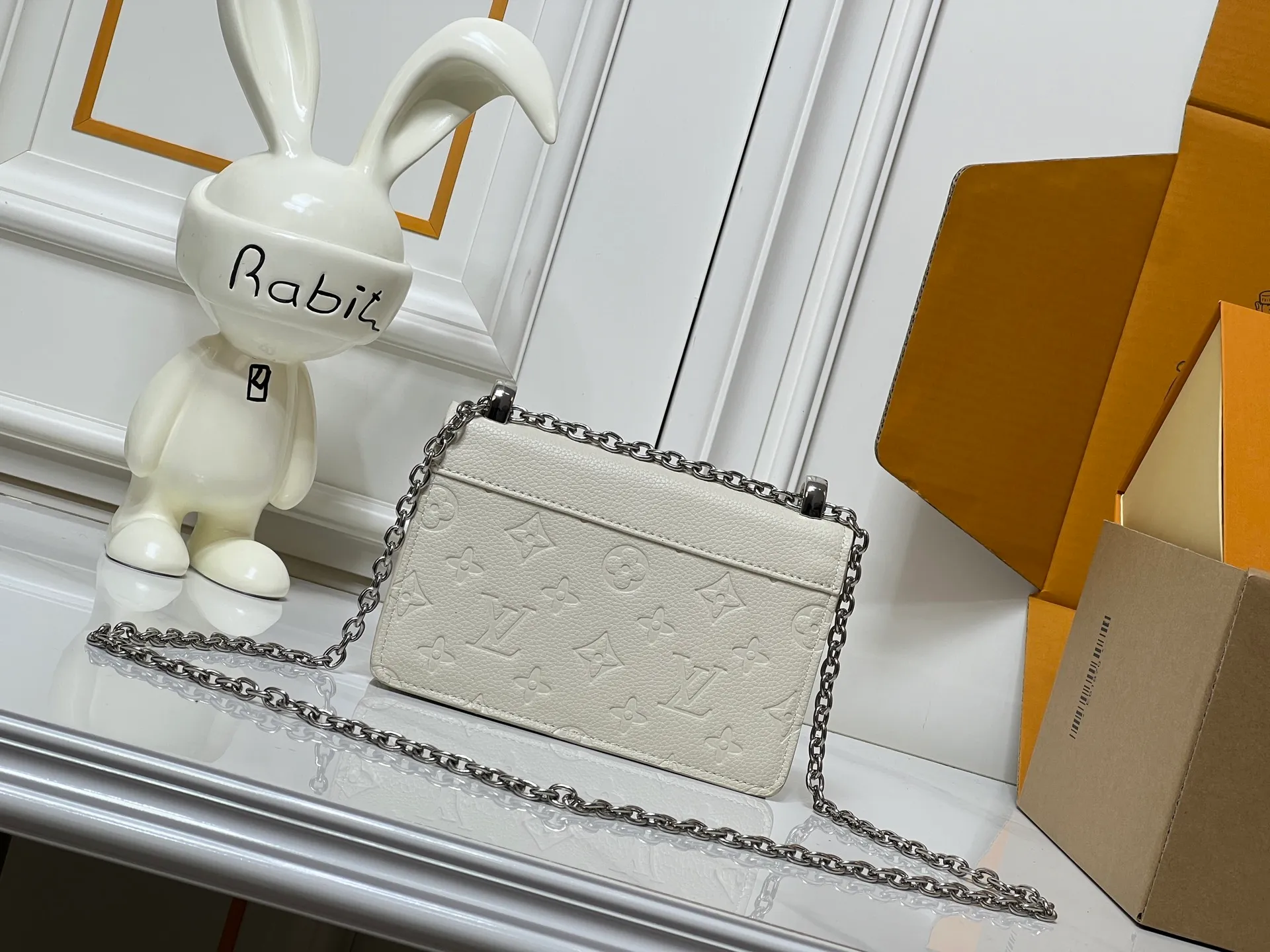 Batch 220💰M13569 black M13570 gray M25814 burgundy (chain/embossed) [Portefeuille chaîne Rosy] This Rosy chain wallet is both fashionable and practical, adding a modern spirit to the Monogram Empreinte series. It has an elegant LV circle and a V-shaped flap, two hallmarks of the house. The magnetic closure reveals a surprise Monogram flower, as well as three card slots and a flat interior pocket. The sliding chain allows you to wear it crosswise or over the shoulder.  Dimensions: 19.5 x 13.5 x 6.5 cm