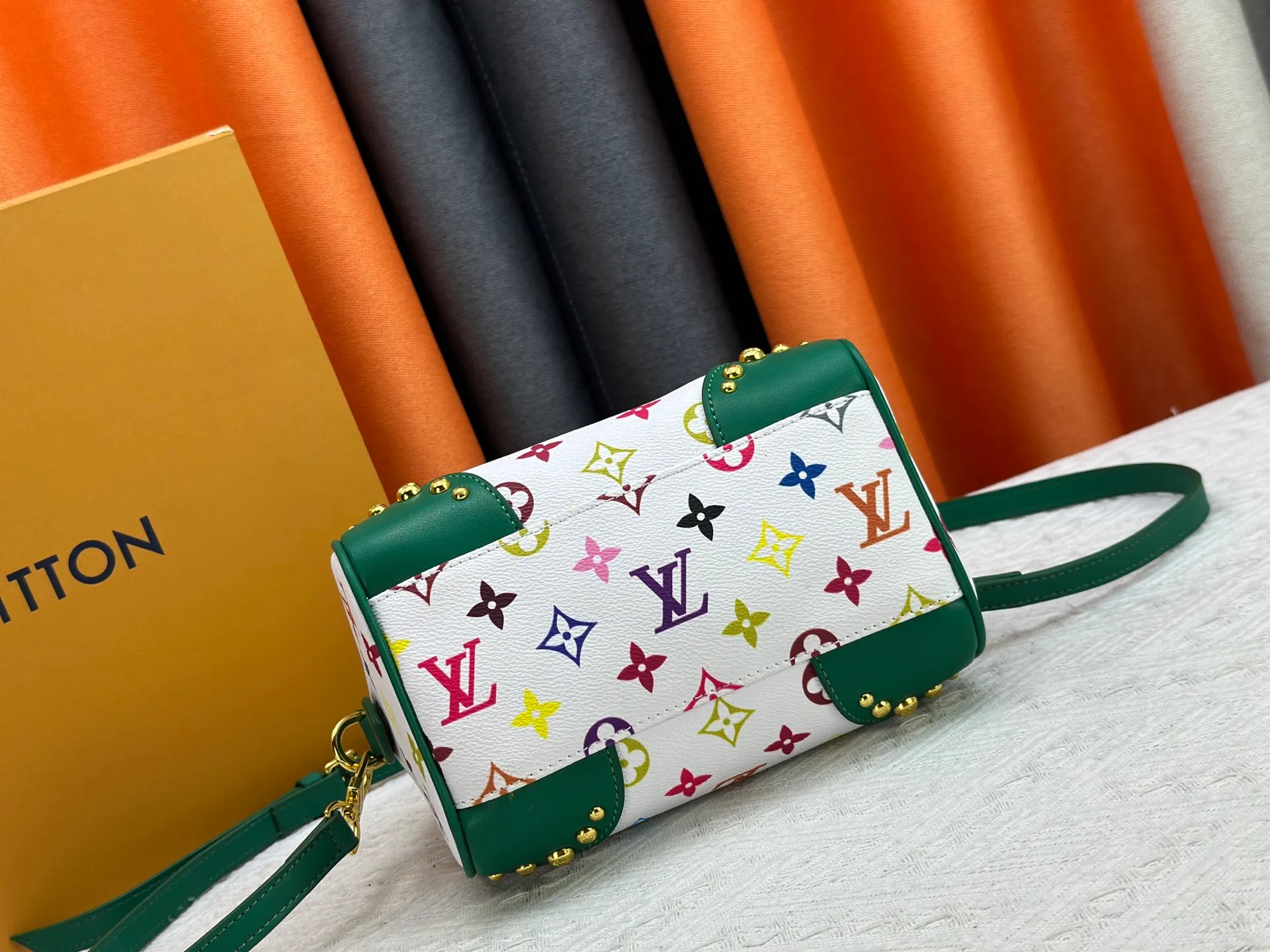 P260 upgraded original M58953 M46234 M46222 Speedy Bandoulière 20 handbag is made of soft coated canvas, and the full-length Monogram pattern is traced in colorful rainbow tones, highlighting the smart style of the Louis Vuitton x Murakami reissue series. The Toron handle and detachable shoulder strap are constructed of cow leather, the metal corners recall classic luggage elements, and the bow-shaped key bag and padlock add brand touches. Dimensions: 20.5 x 13.5 x 12.0 cm (length x height x width)